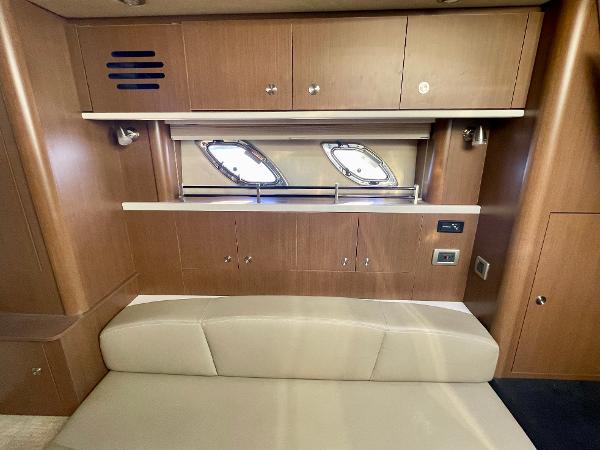Interior of 2014 Sea Ray 330 Sundancer with wooden cabinets and beige seating.