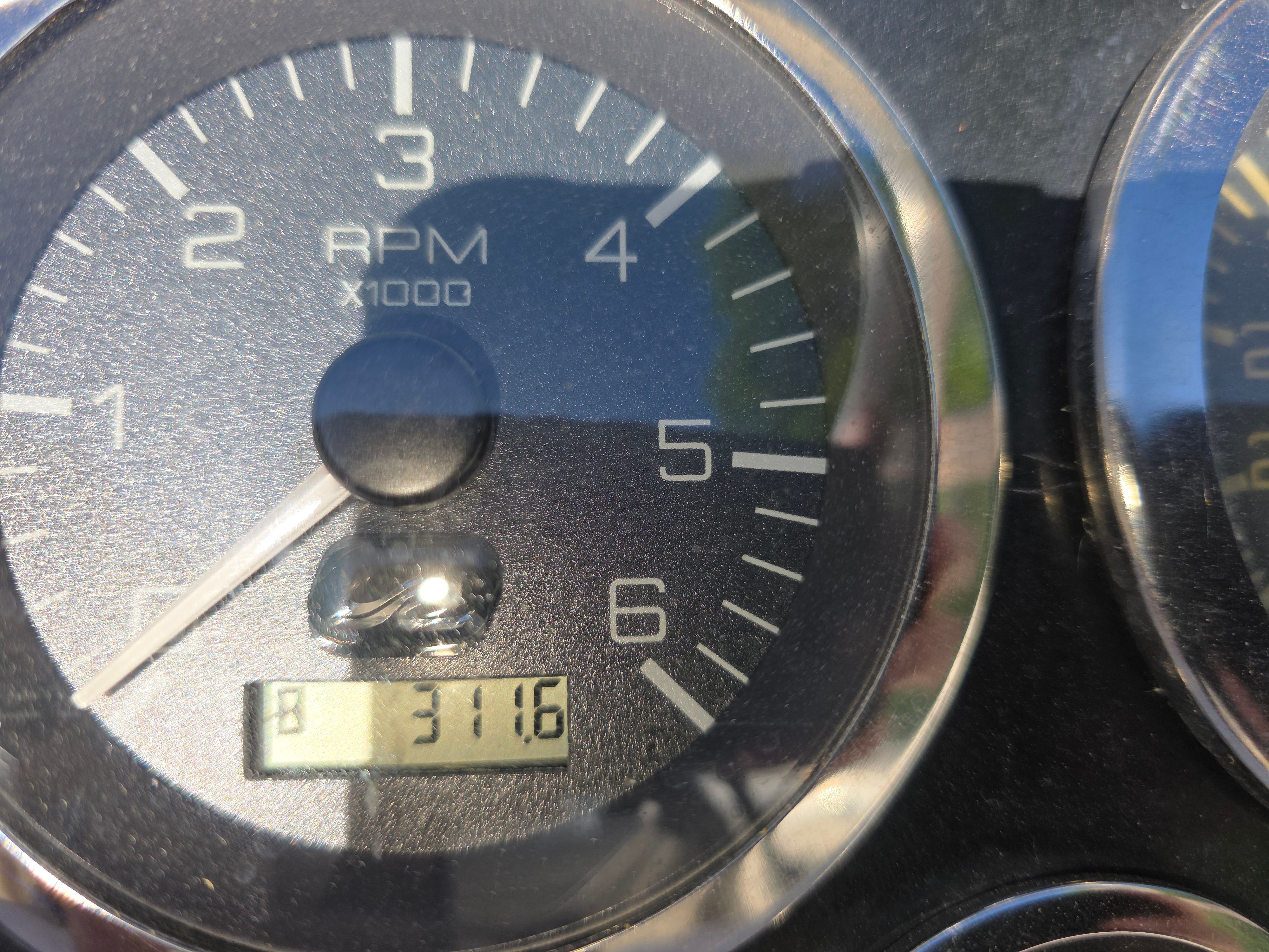 Close-up of a tachometer showing 3116 RPM.