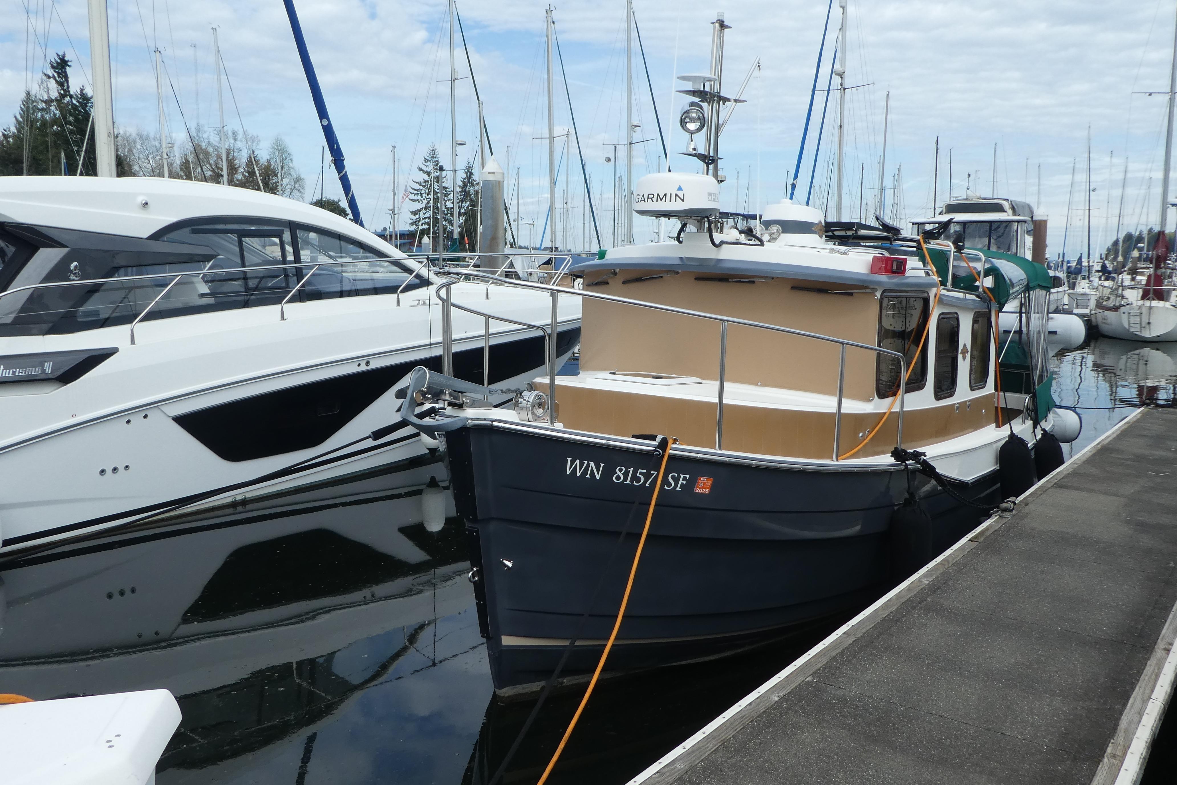 2015 Ranger Tugs R-25 SC docked at a marina, surrounded by other boats.