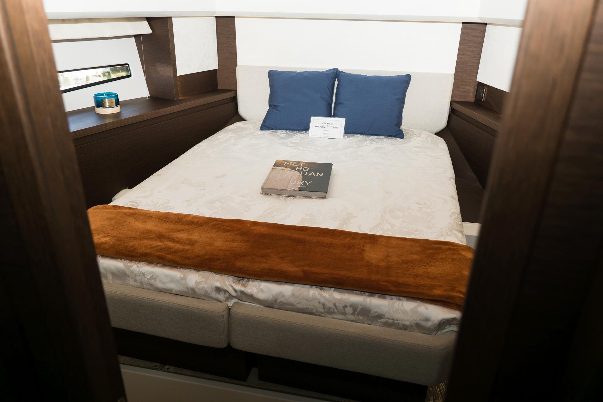 Luxurious bedroom interior of 2022 Prestige 460 yacht with cozy bedding and decor.
