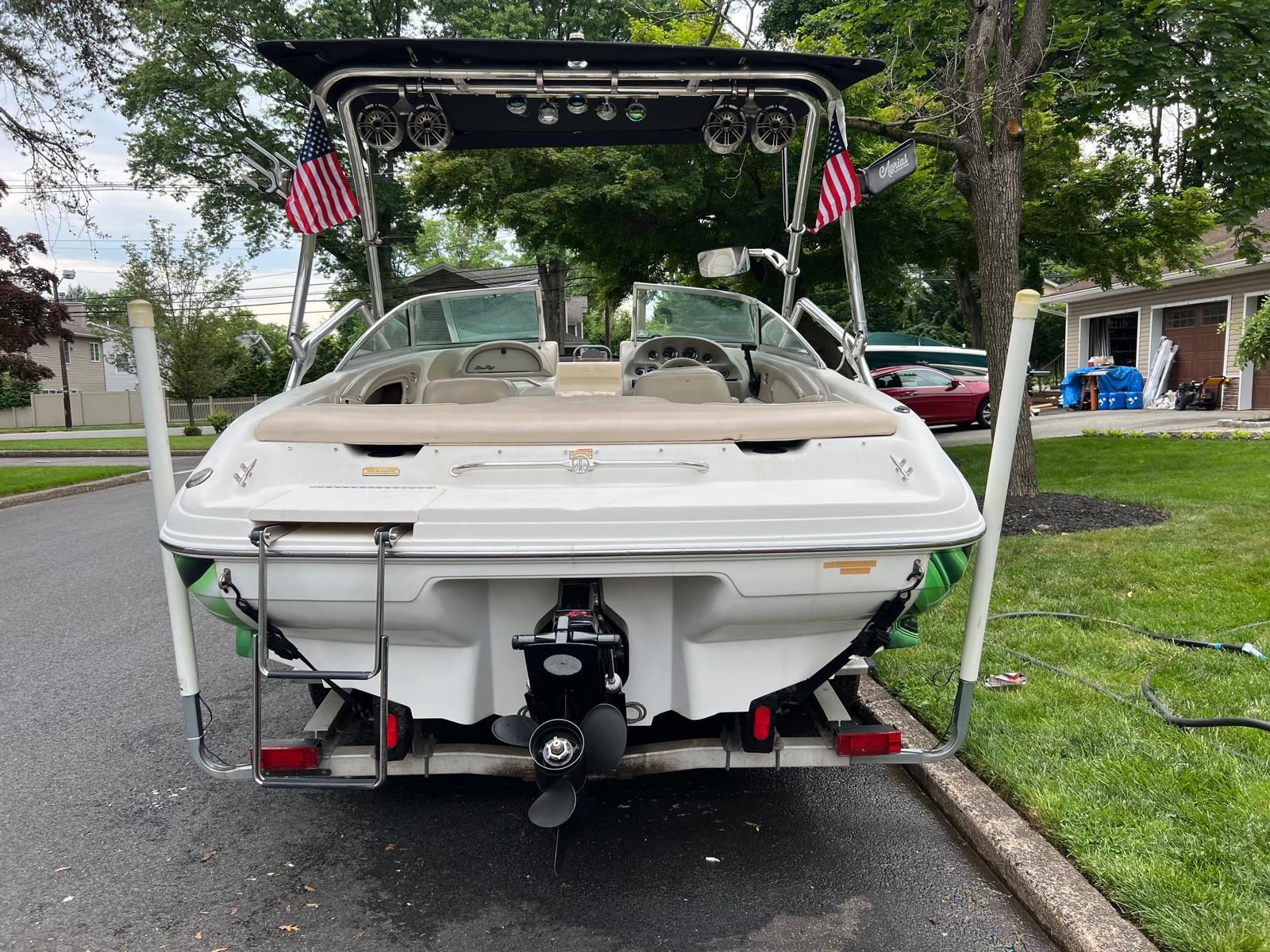 Rear view of a 1997 Sea Ray 190 Bow Rider on a trailer, with two American flags.