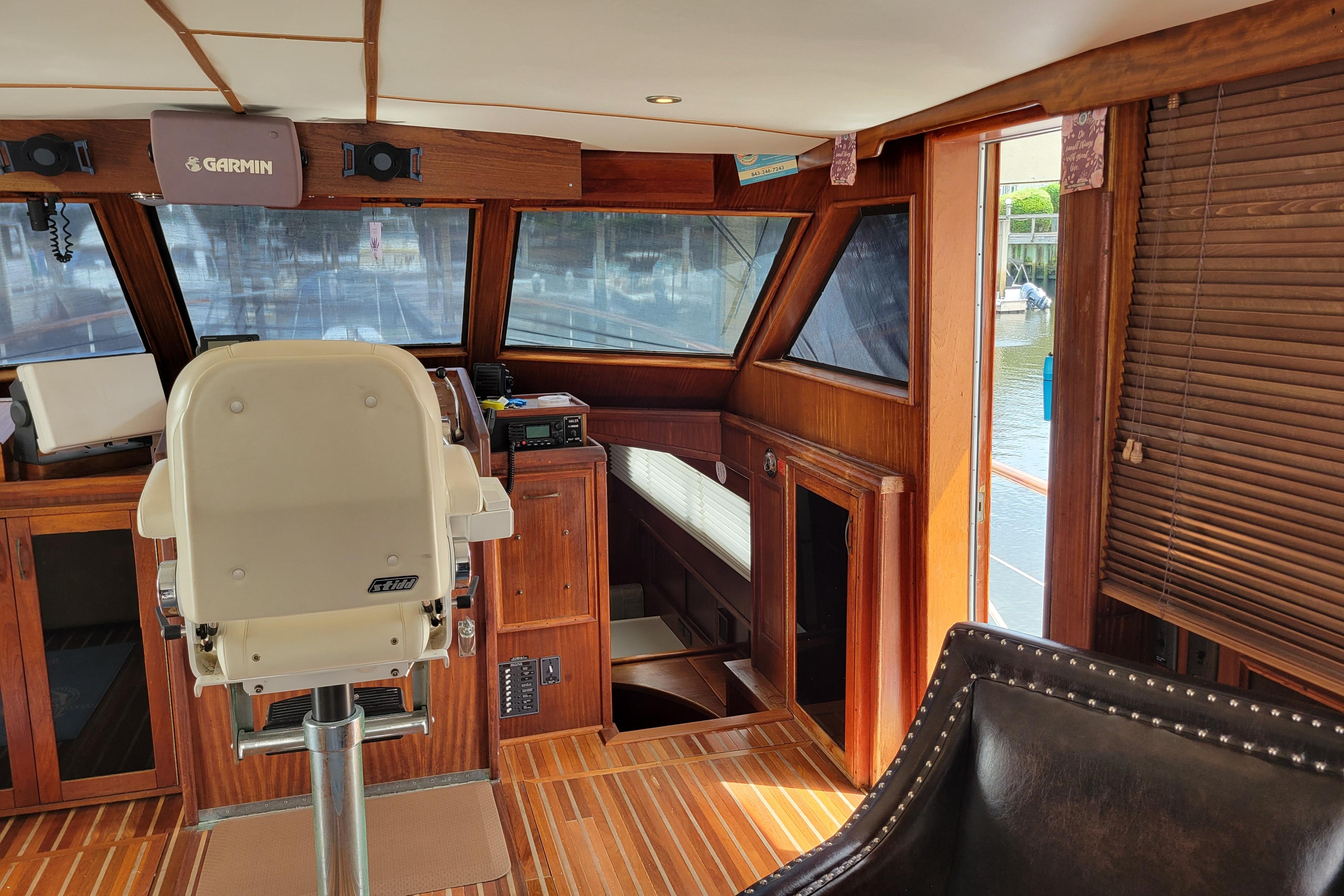 Interior of 1980 Hatteras 53 Yacht Fisherman with helm and wooden accents.