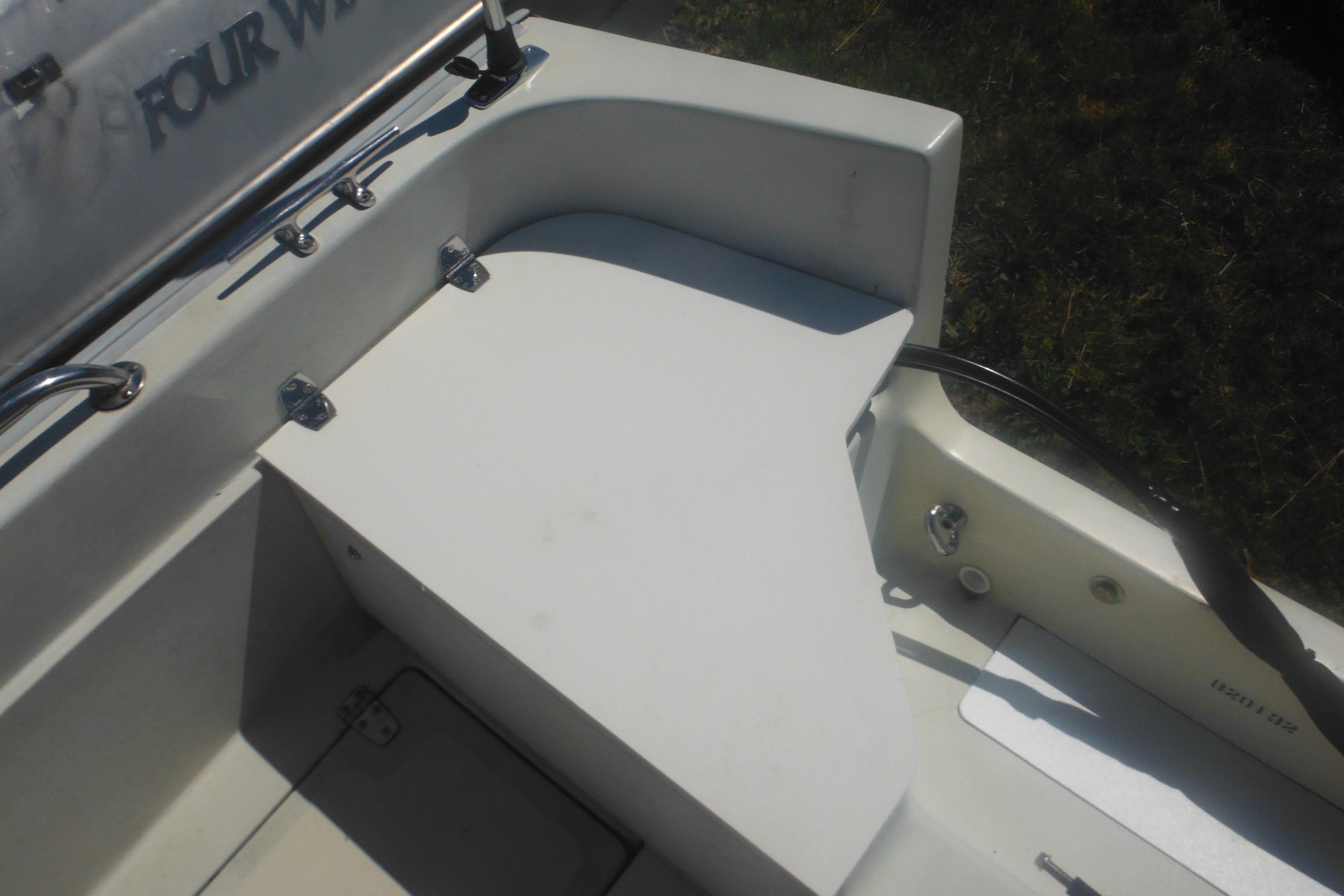 1991 Boston Whaler 16 SL boat interior with storage compartment and railing.