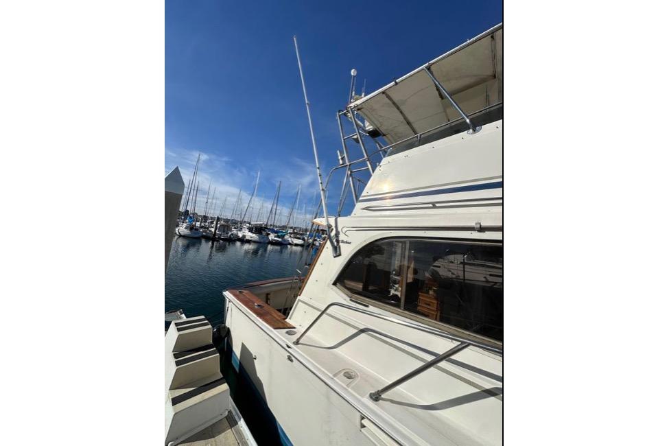 1985 Egg Harbor 33 Sedan yacht docked at a marina under clear blue skies.