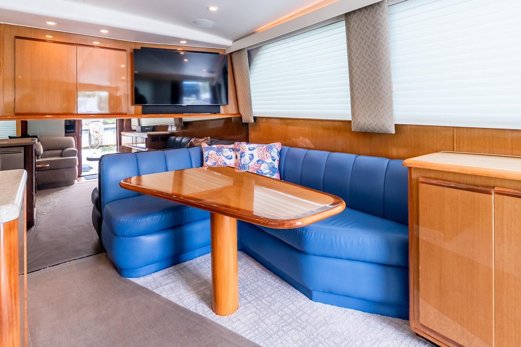 Interior of 2000 Viking 50' Convertible yacht with blue seating and wooden table.