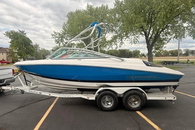 2007 Regal 2200 Bowrider boat on trailer, parked outdoors with trees in background.