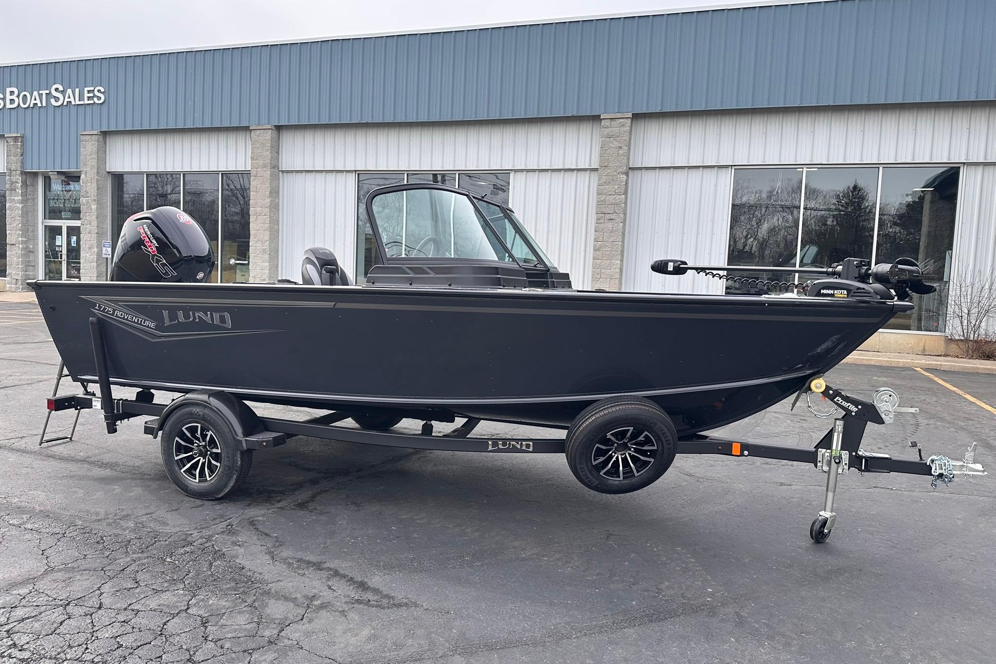 2026 Lund 1775 Adventure Sport boat on trailer outside dealership.
