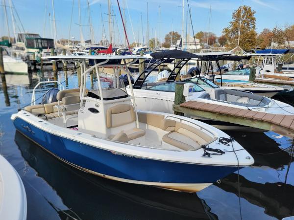 2021 NauticStar 2302 Legacy boat docked in a marina with other boats.