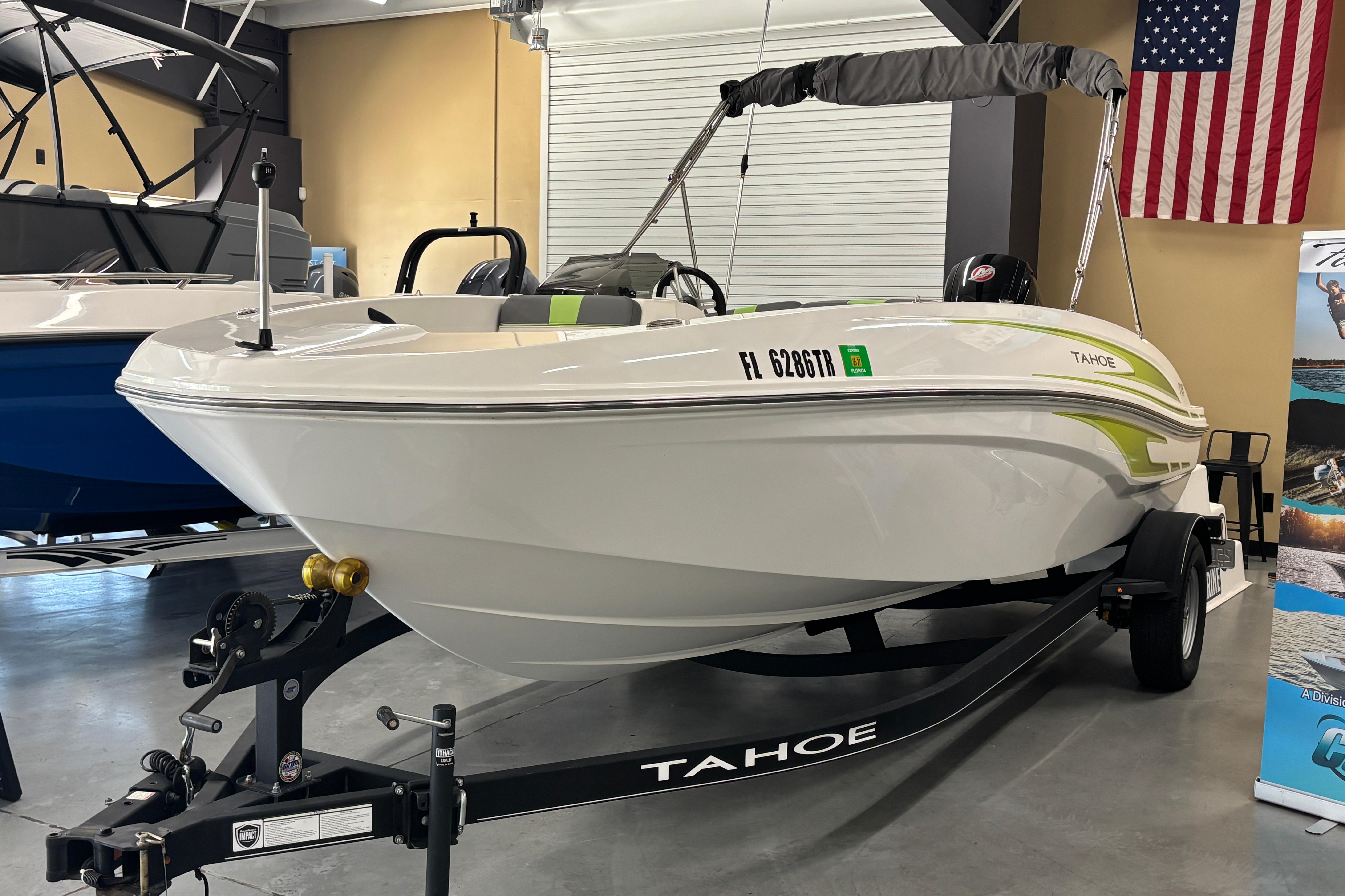 2024 Tahoe T18 boat displayed indoors with trailer and American flag.