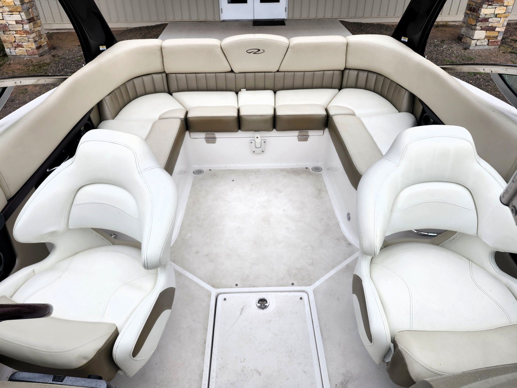 Boat interior with beige and white seating, U-shaped arrangement.