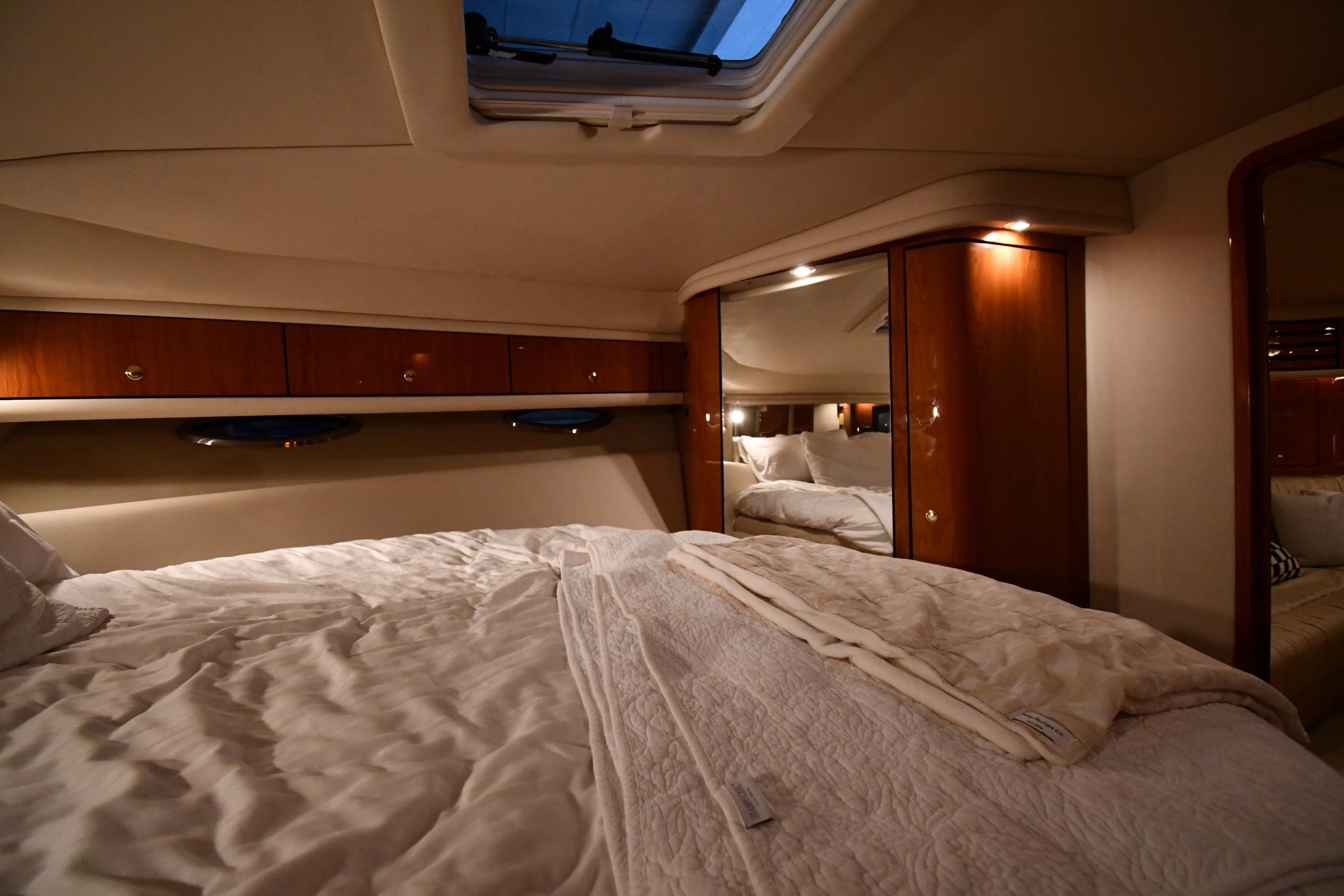 Luxurious cabin interior of 2001 Sea Ray 540 Sundancer yacht with cozy bedding.