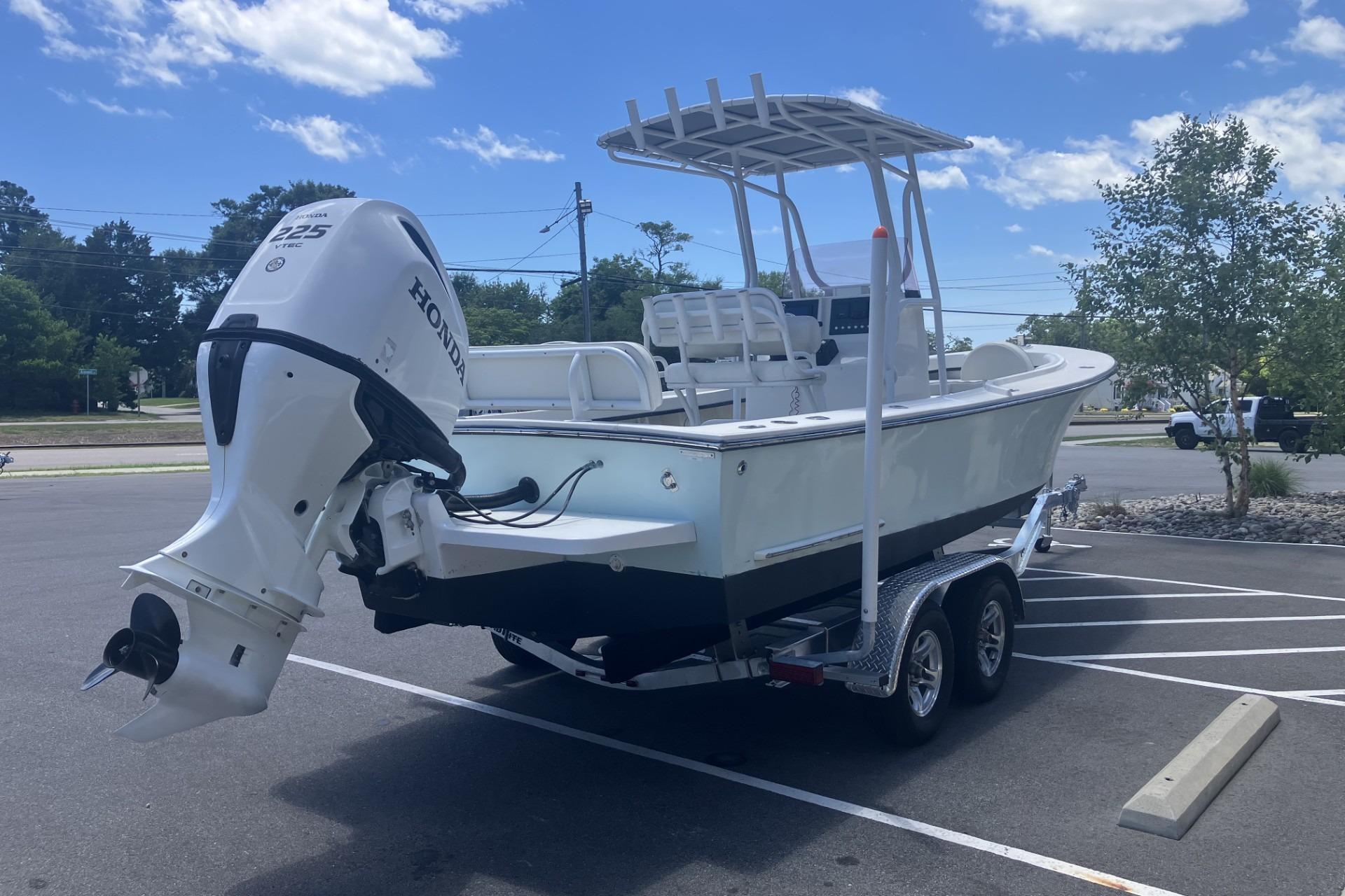 2022 May-Craft 2300 CCX boat on trailer with Honda outboard motor in parking lot.