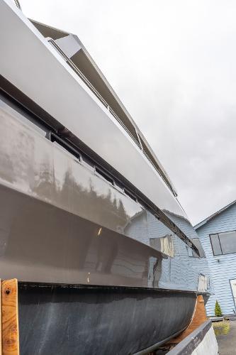 2025 Catamaran Bloomfield 86 Motorsailor, sleek design, docked near a blue building.