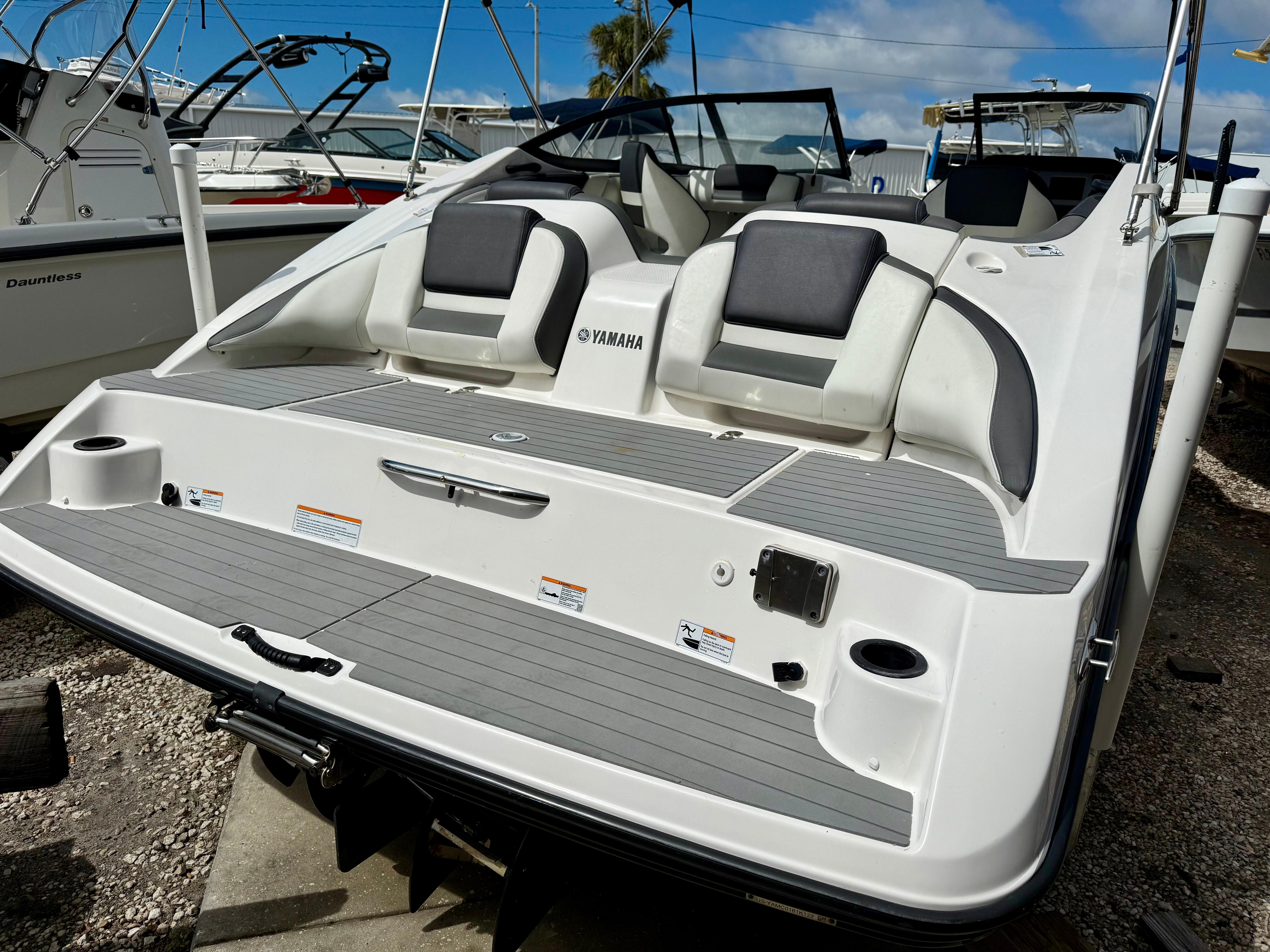 2022 Yamaha SX210 boat with sleek design and comfortable seating, docked under a clear blue sky.