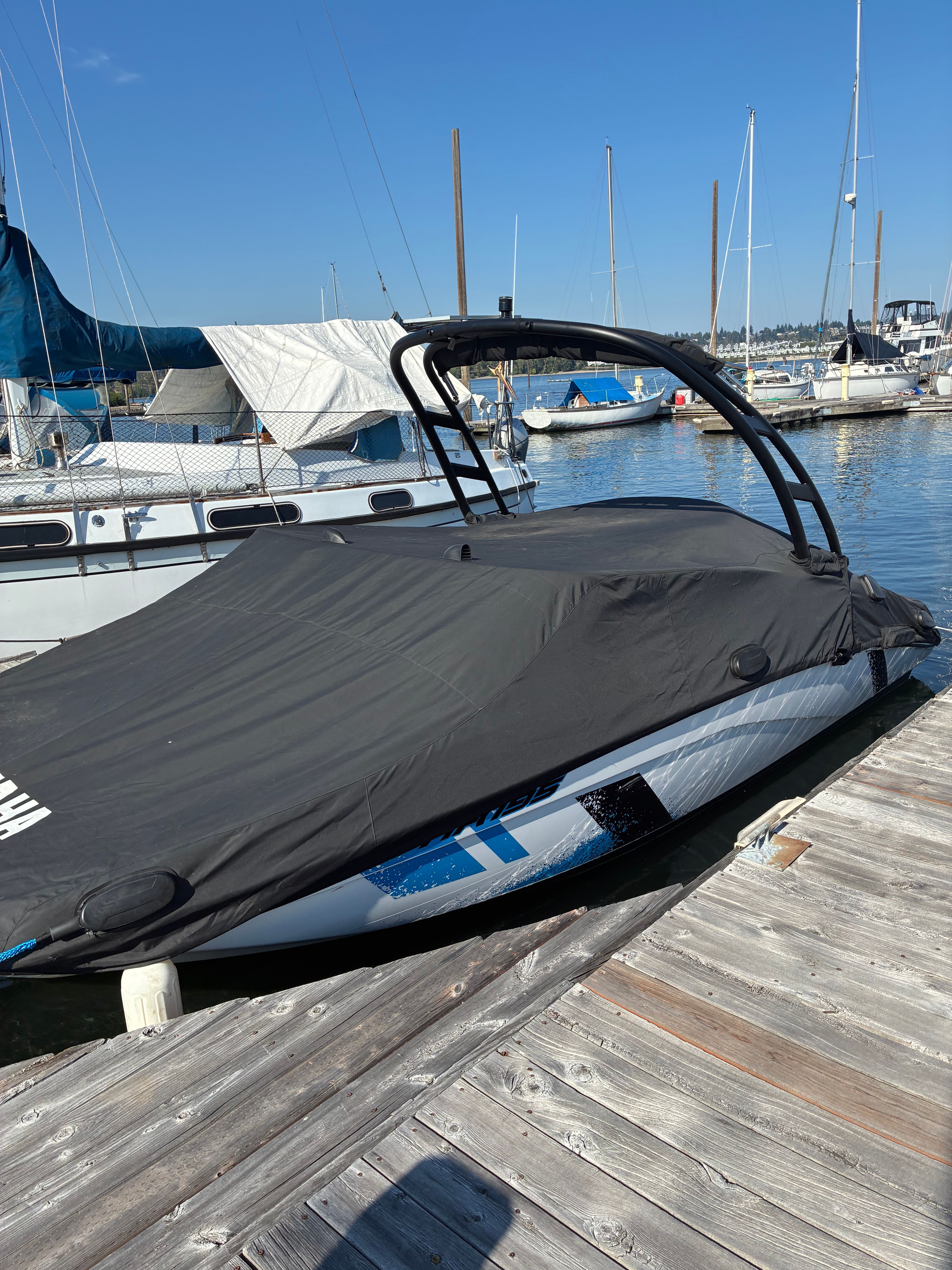 A 2022 Yamaha AR195 boat is docked with a cover in the marina.