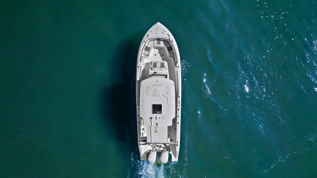 Aerial view of 2021 Pursuit S 328 Sport boat cruising on clear blue water.