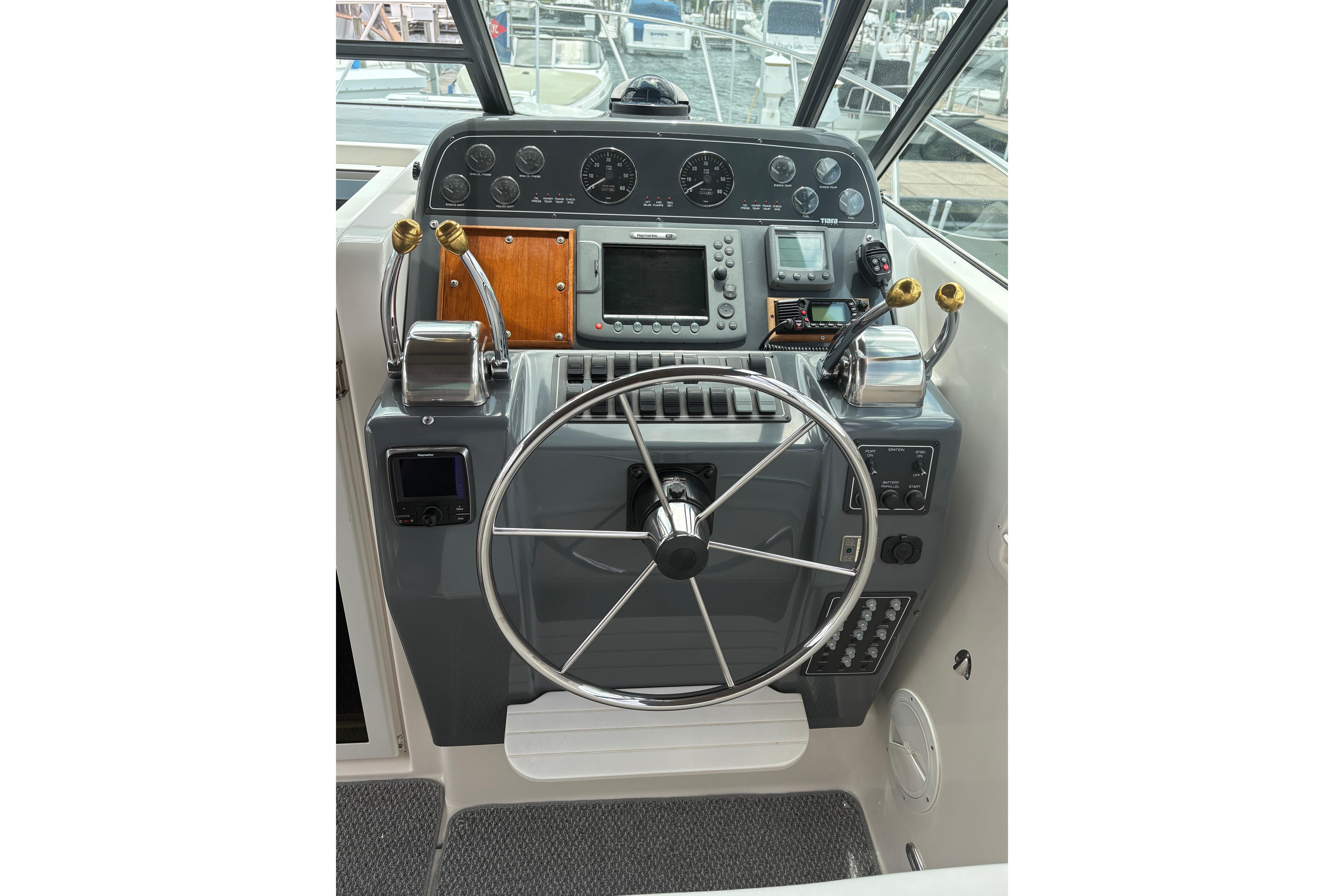 1999 Tiara Yachts 3100 Open helm with steering wheel, controls, and navigation instruments.