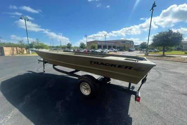 2026 Tracker Grizzly 1648 Utility boat on trailer in sunny parking lot.
