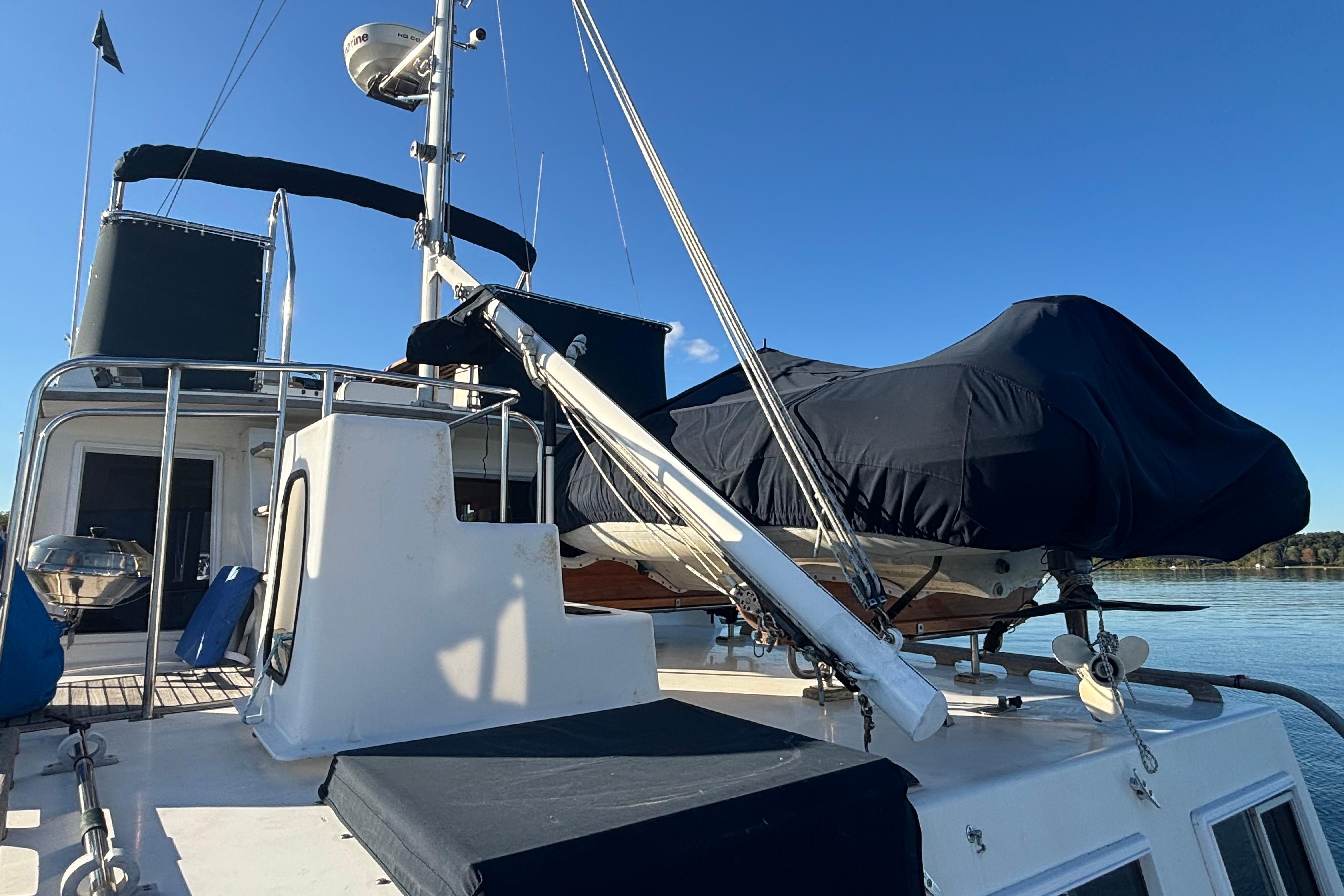 1989 Grand Banks 46 Classic yacht deck with covered equipment, clear blue sky.