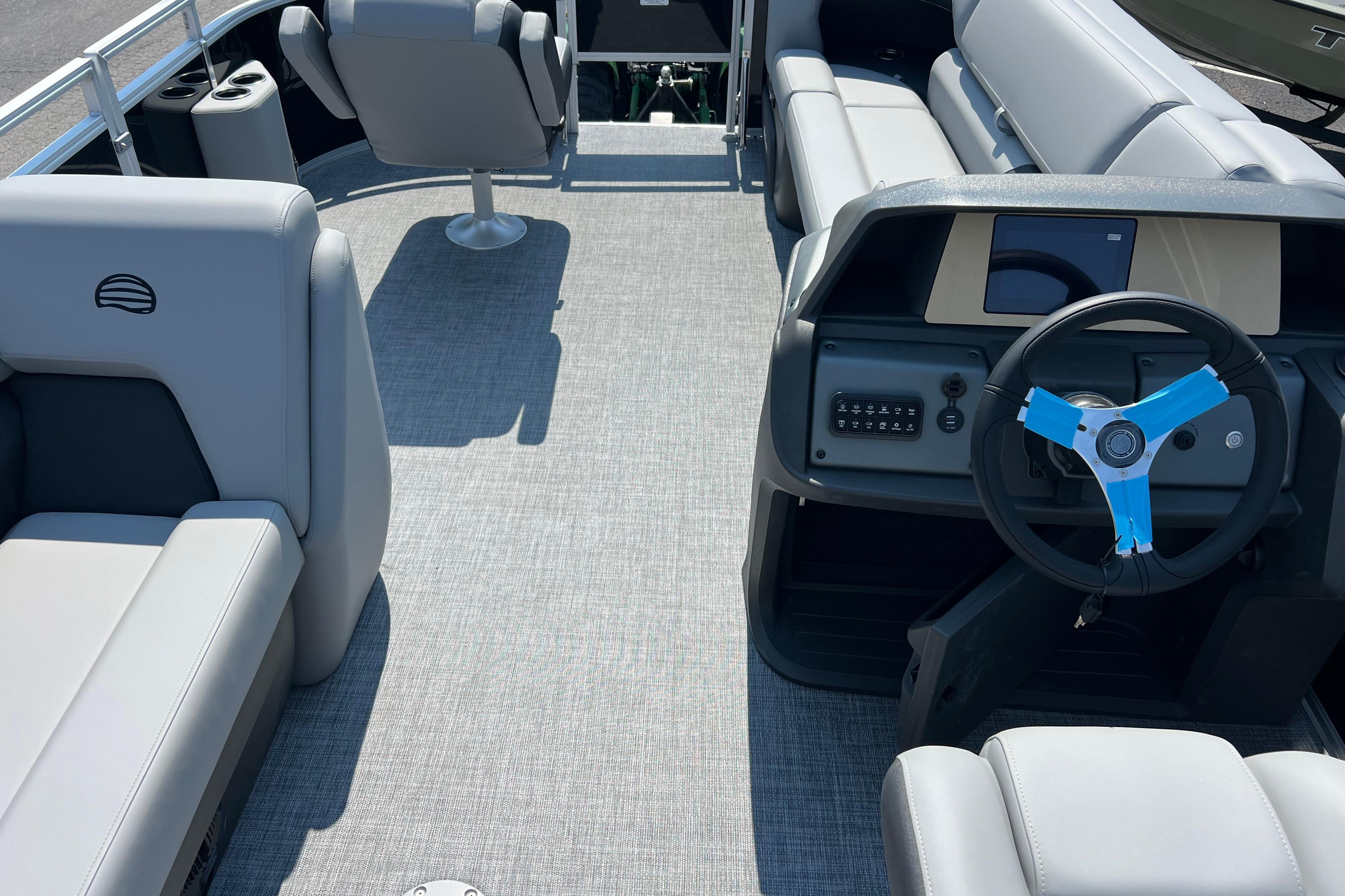 2026 Sun Tracker SportFish 20 DLX pontoon boat interior with steering wheel and seating.