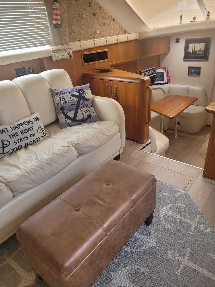 Interior of 1999 Silverton 37 Convertible yacht with cozy seating and nautical decor.