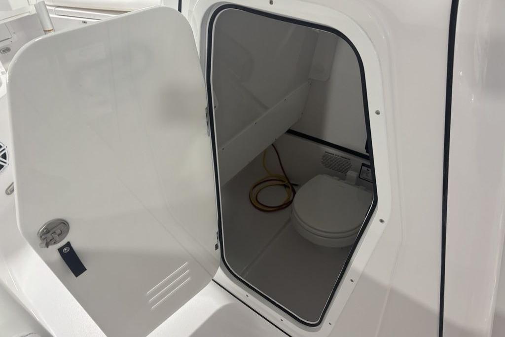 2026 Sportsman Open 252 Center Console boat interior with open door and toilet.