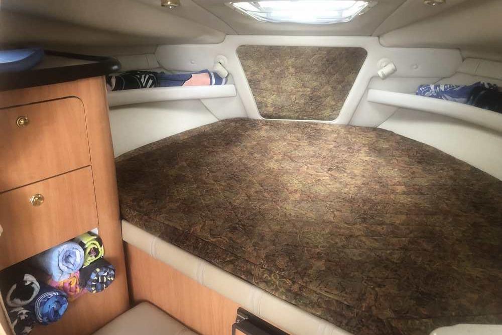 1999 Regal Commodore 2760 cabin interior with bed and storage cabinets.