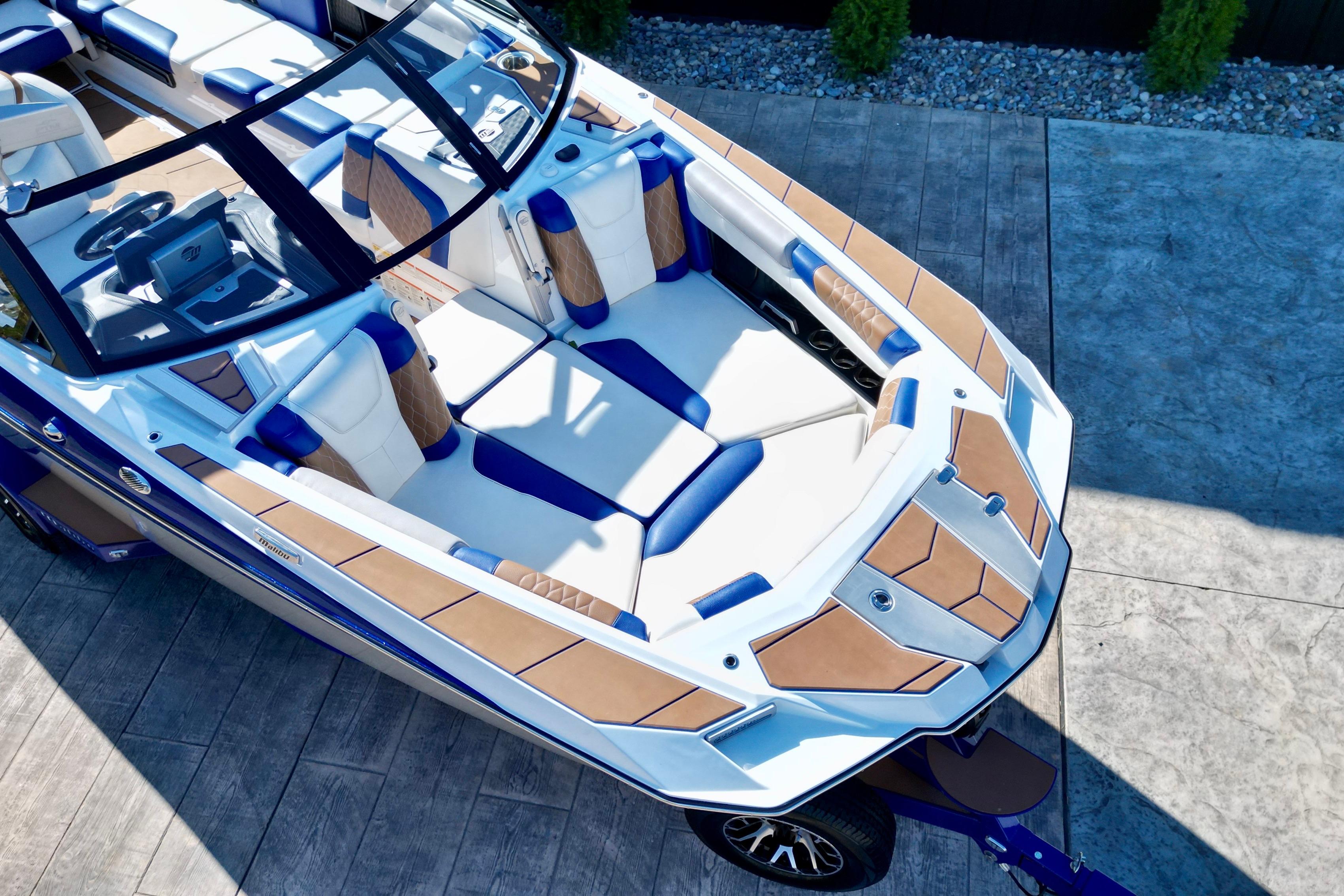 2022 Malibu M240 boat with luxurious seating and sleek design on a concrete surface.