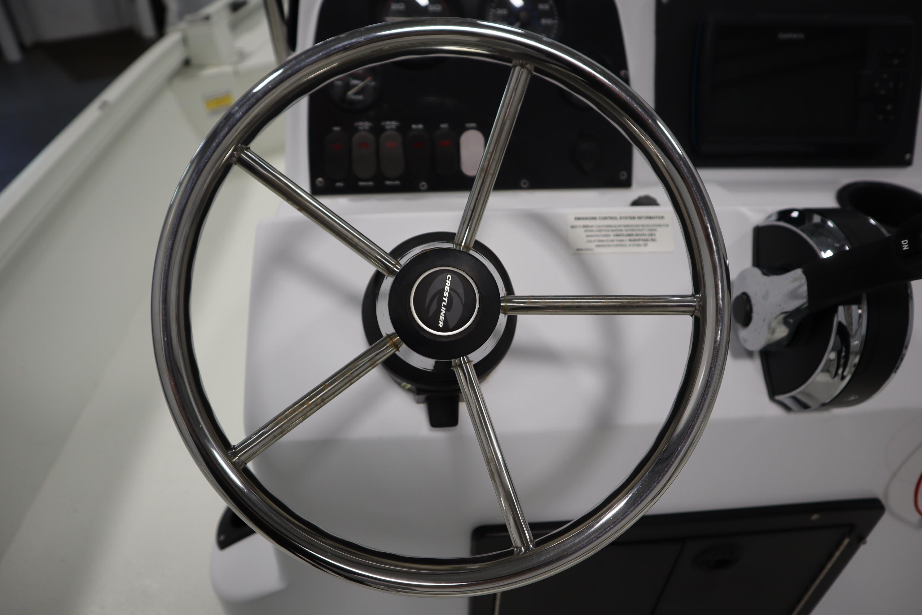 Steering wheel of 2022 Crestliner 2200 CC boat, featuring sleek chrome design.