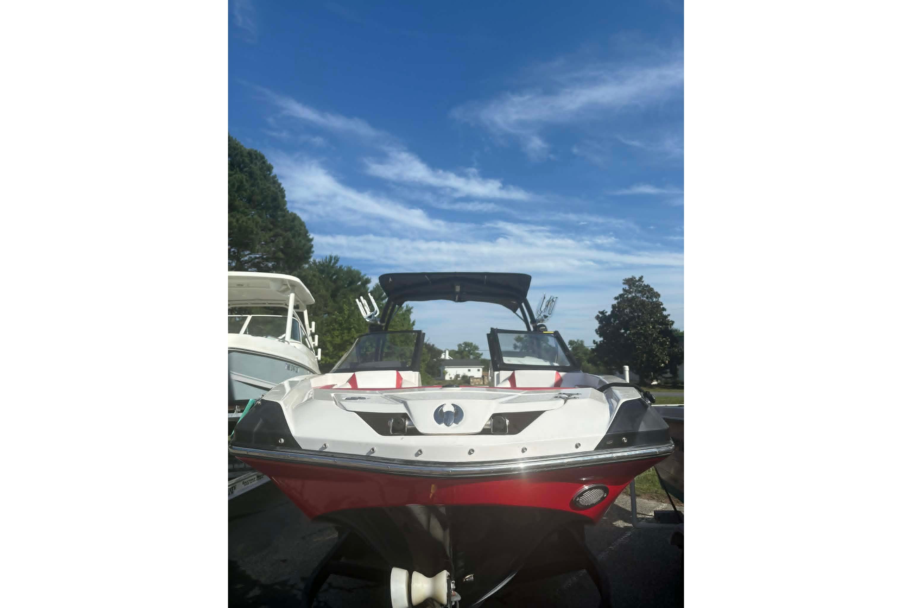 2016 Scarab 255 H.O. Impulse boat with red and white design under a clear blue sky.