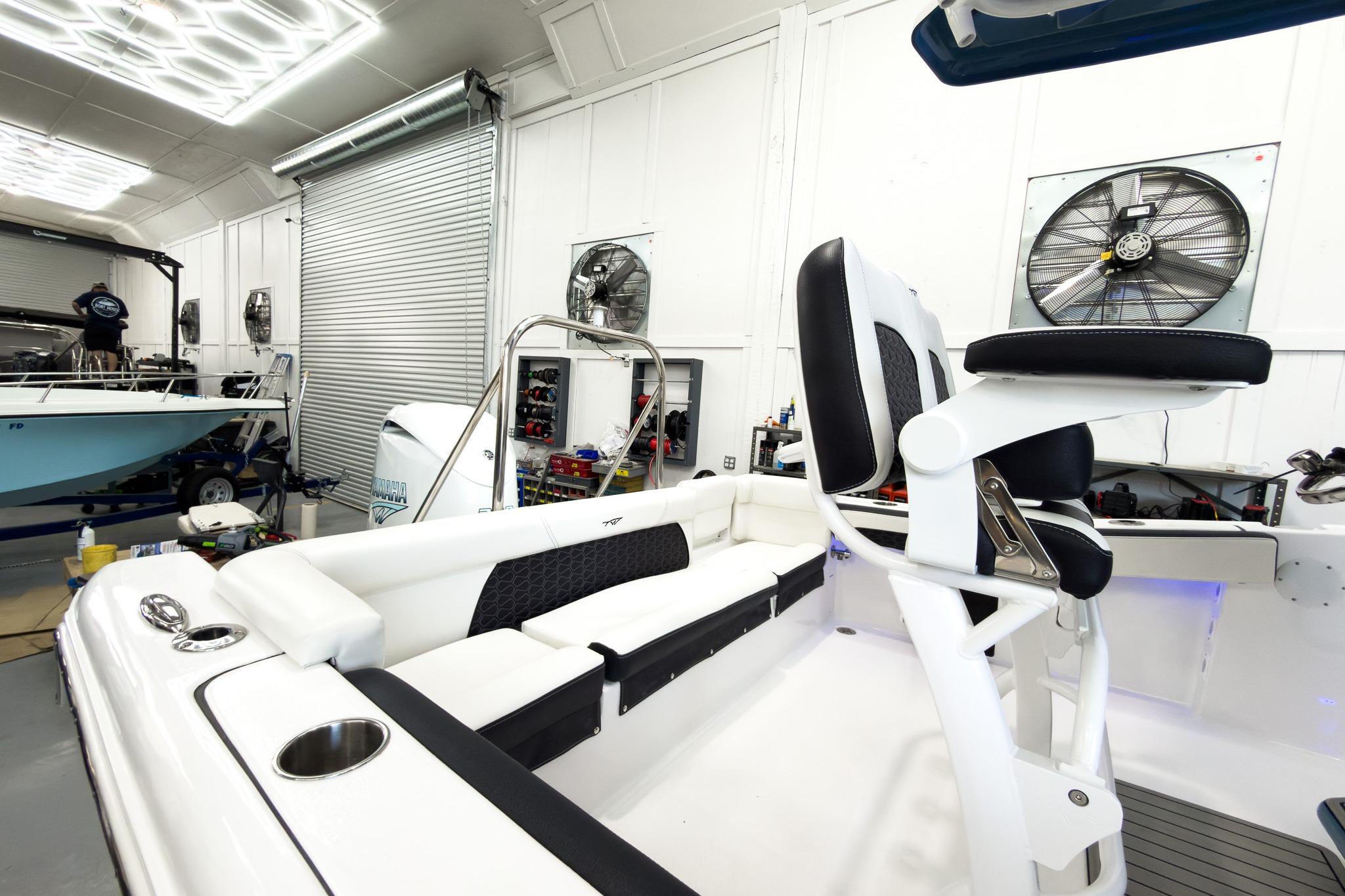 The image shows the interior of a Tidewater 220 LXF boat in a workshop.