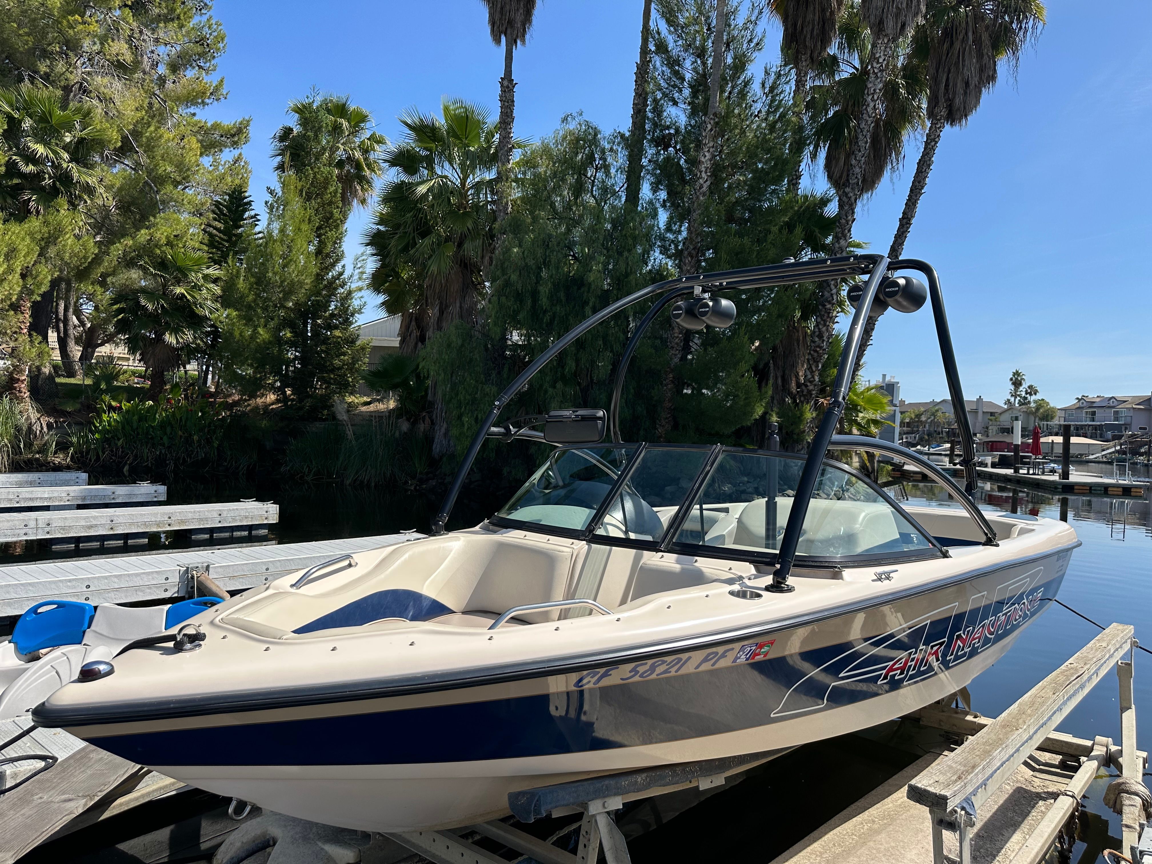 1998 Correct Craft Air Nautique boat at dock.