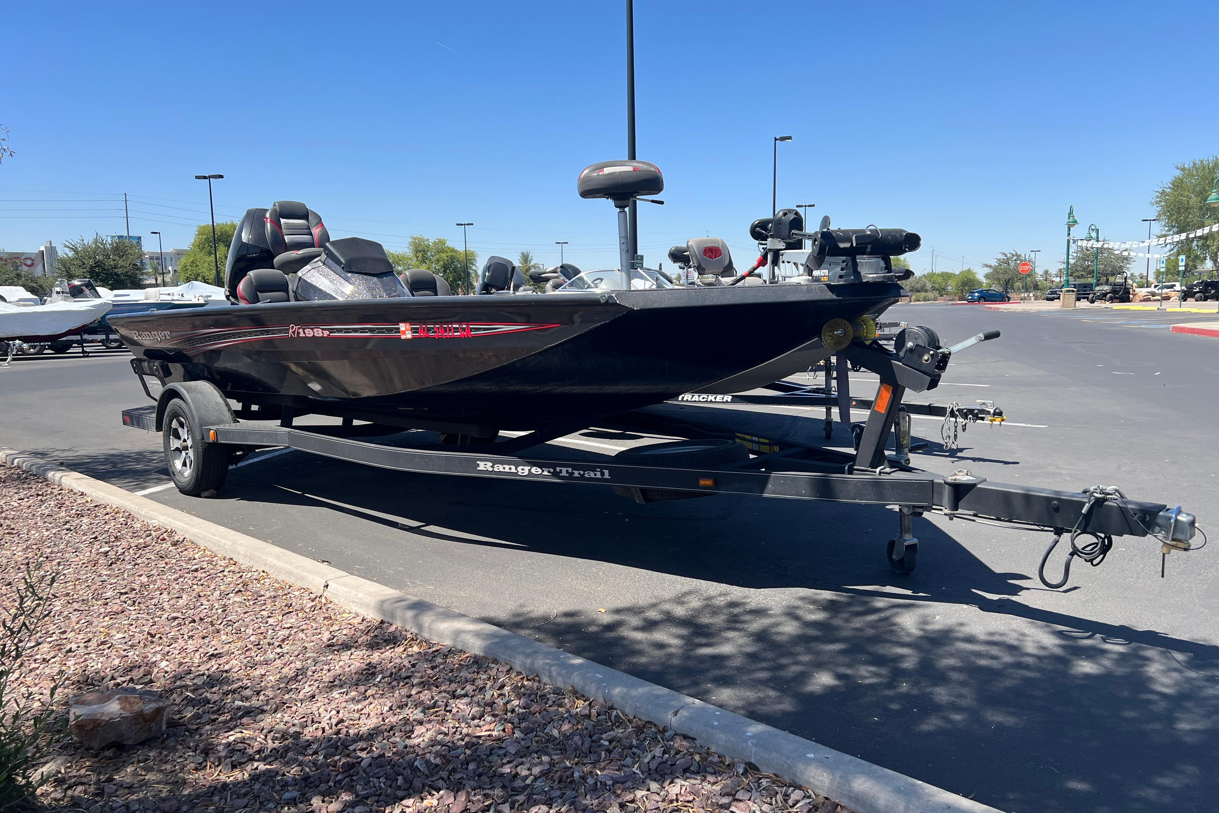 2019 Ranger RT198P boat on trailer in parking lot under clear blue sky.