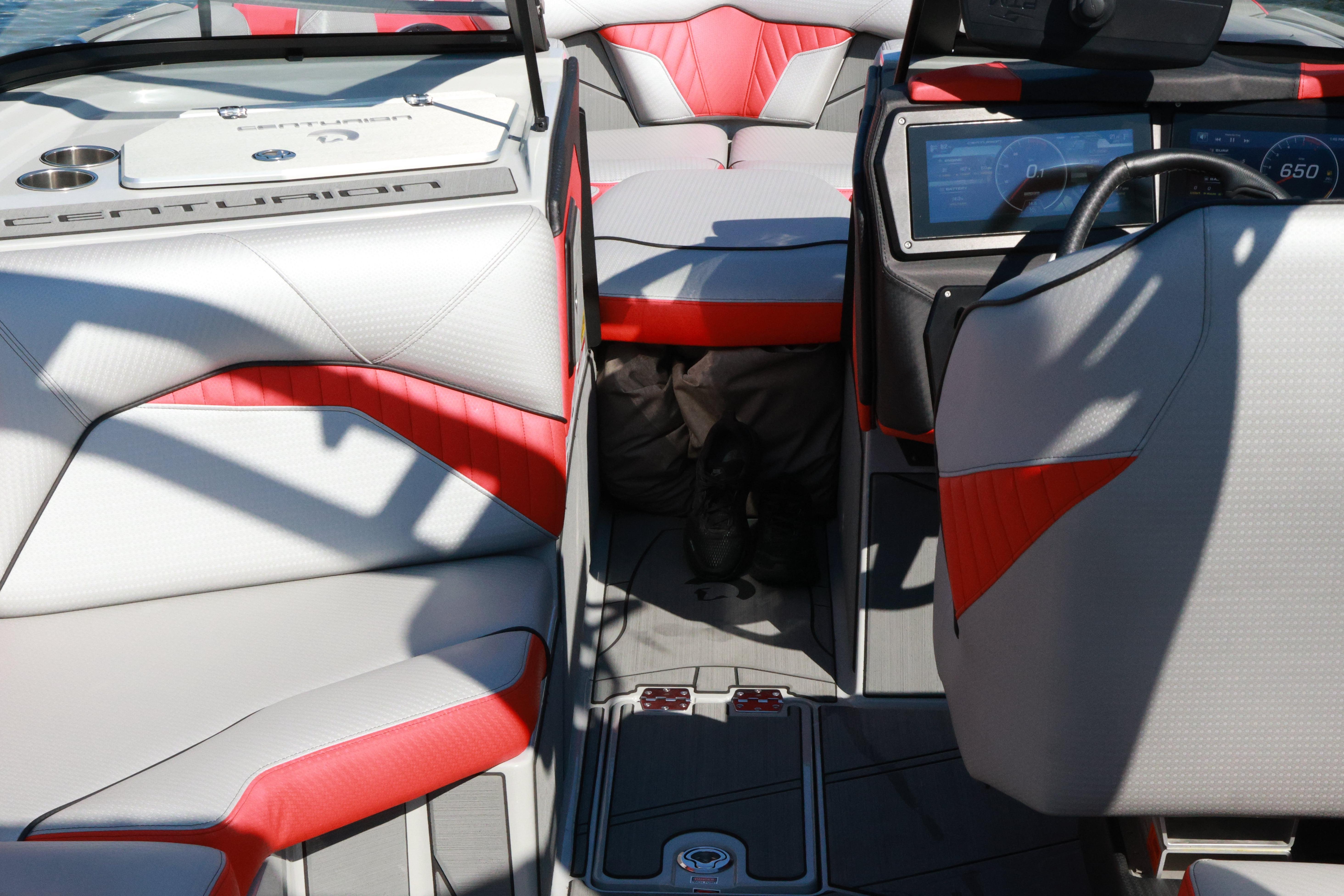 2024 Centurion Fi23 boat interior with red and gray seating, modern dashboard, and steering wheel.