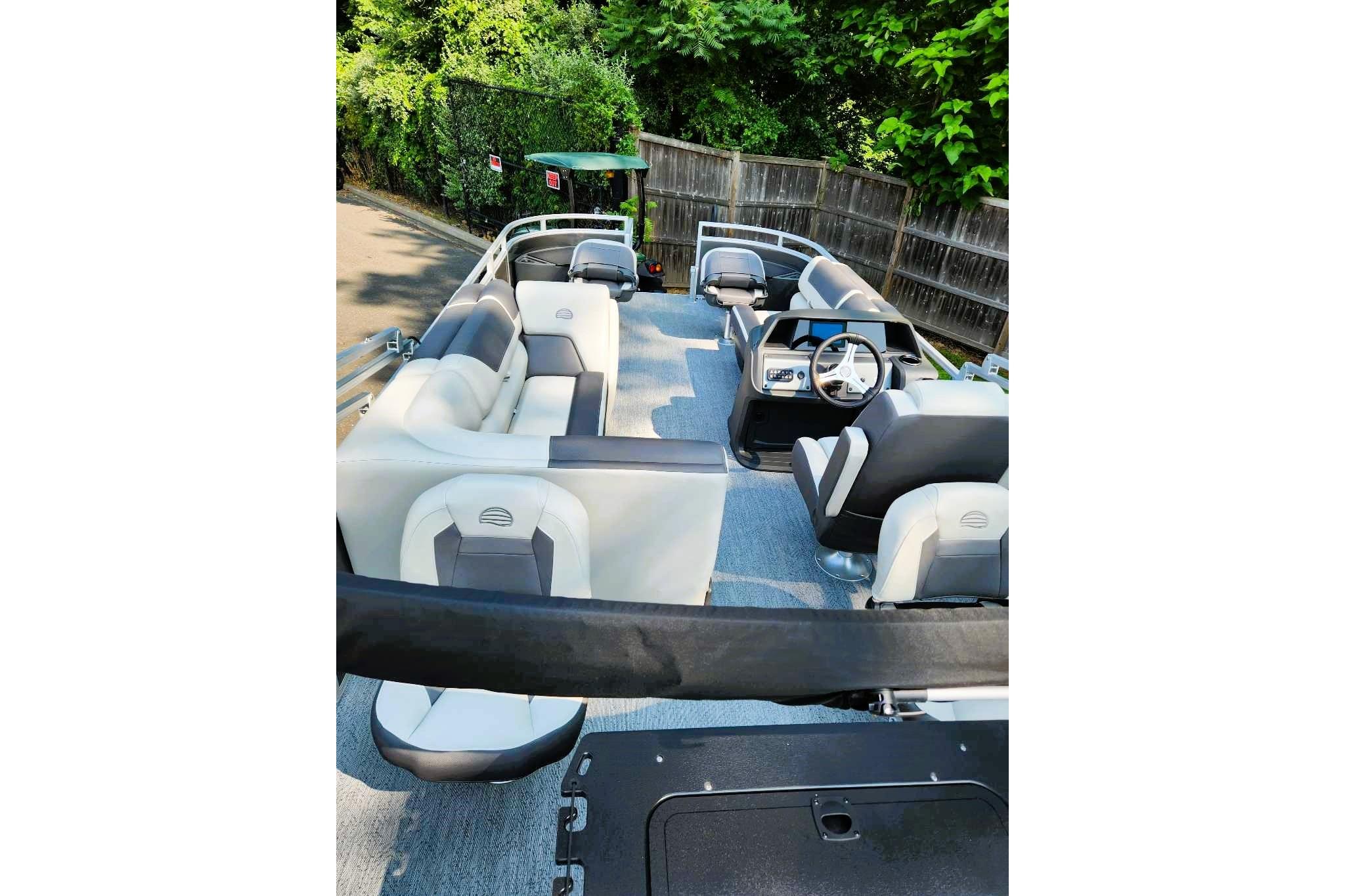 2026 Sun Tracker Fishin' Barge 20 DLX interior with seating and steering console.