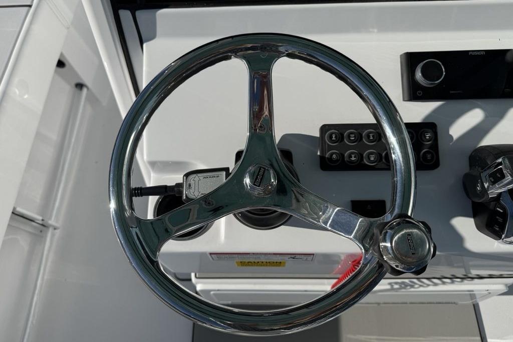 Steering wheel of 2026 Sportsman Masters 247OE Bay Boat, featuring control panel and throttle.