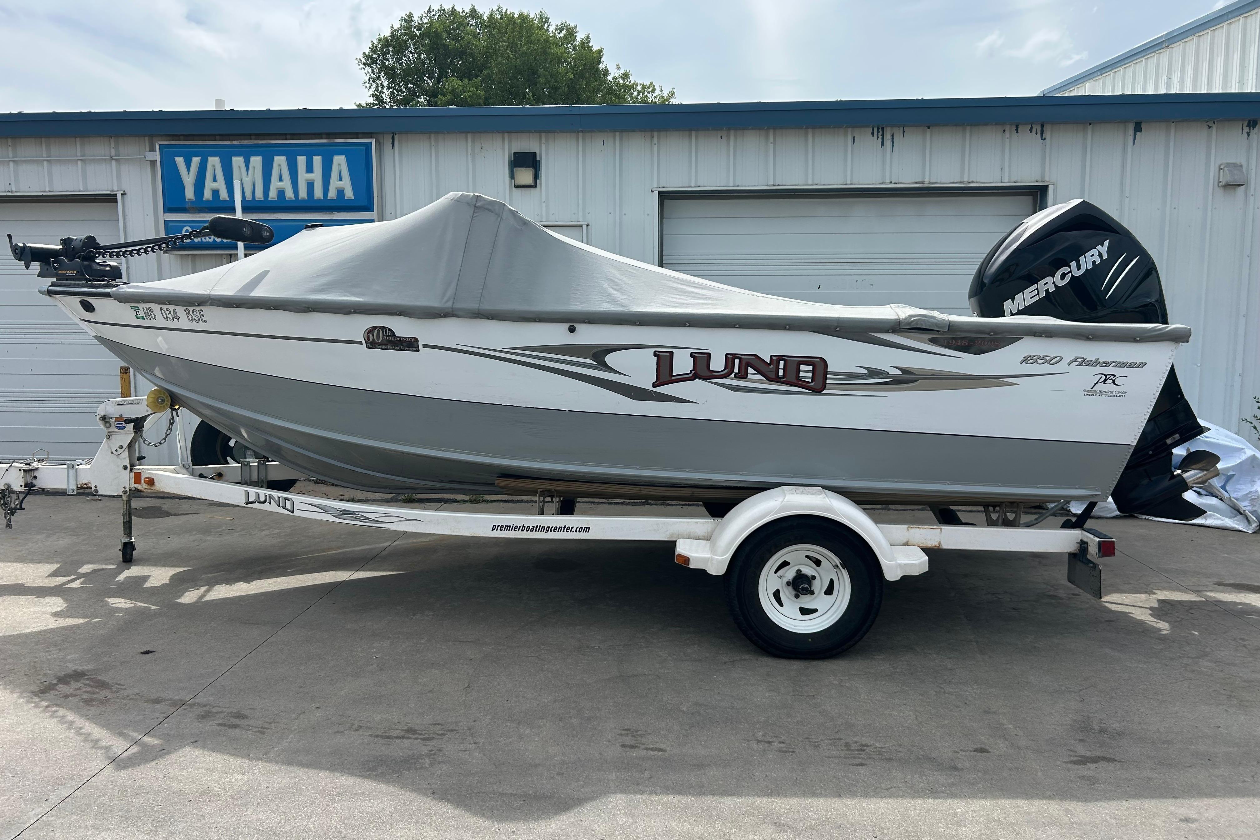 2008 Lund 1850 Fisherman boat on trailer, covered, with Mercury outboard motor.