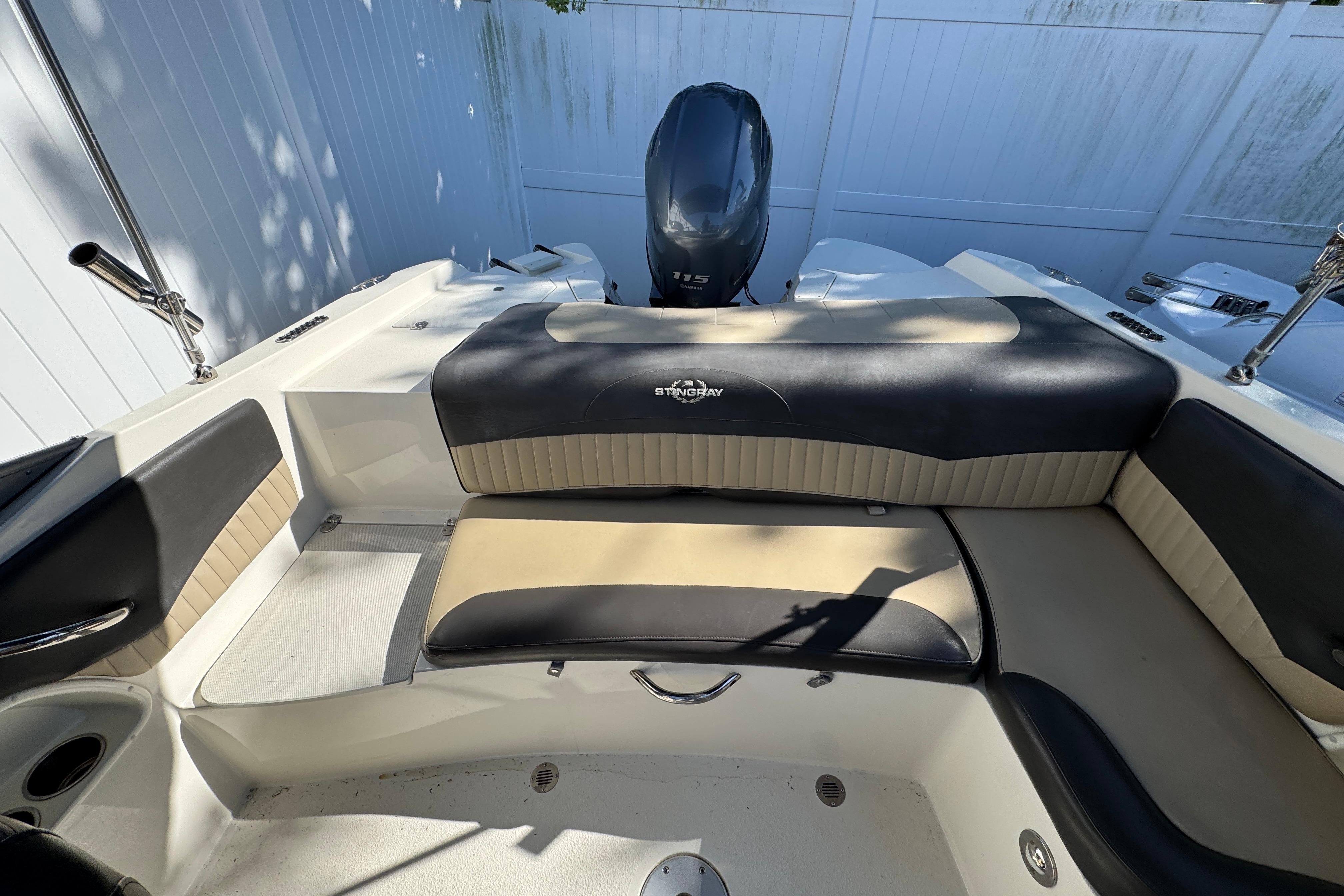 2018 Stingray 204 LR boat interior with cushioned seating and motor, in a sunny setting.