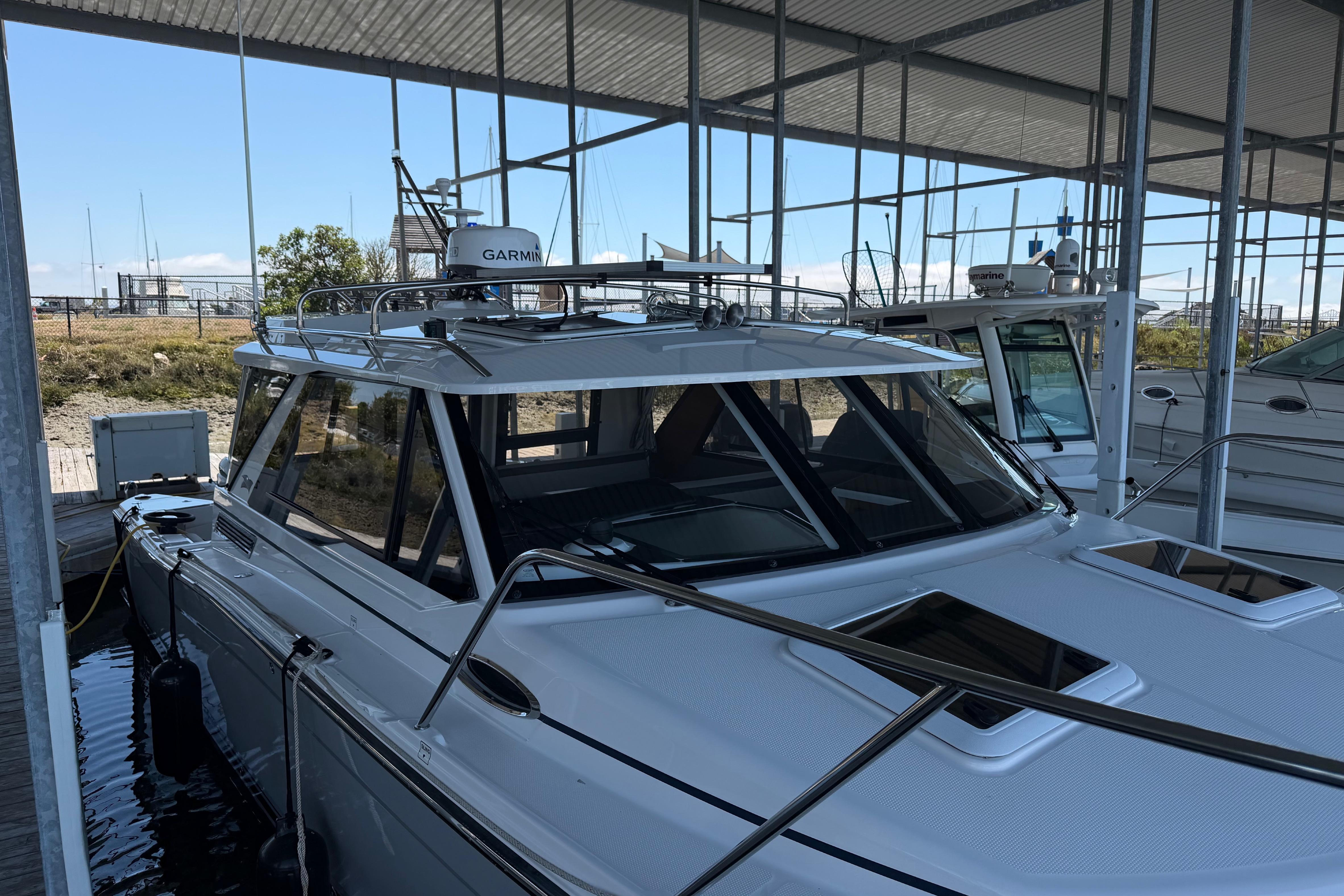2023 Cutwater C-288 Coupe docked under a covered marina, showcasing sleek design and modern features.