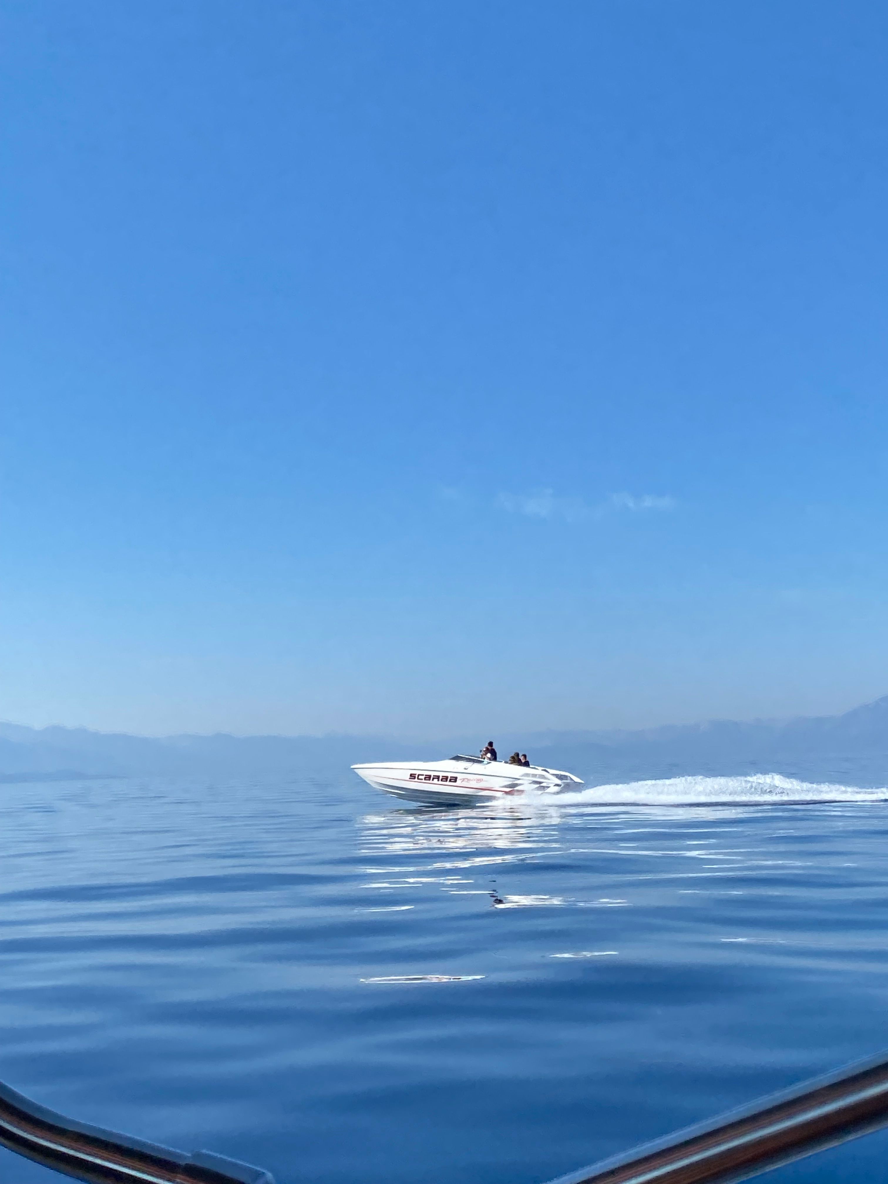 1997 Wellcraft 29 Scarab on calm water under blue sky.