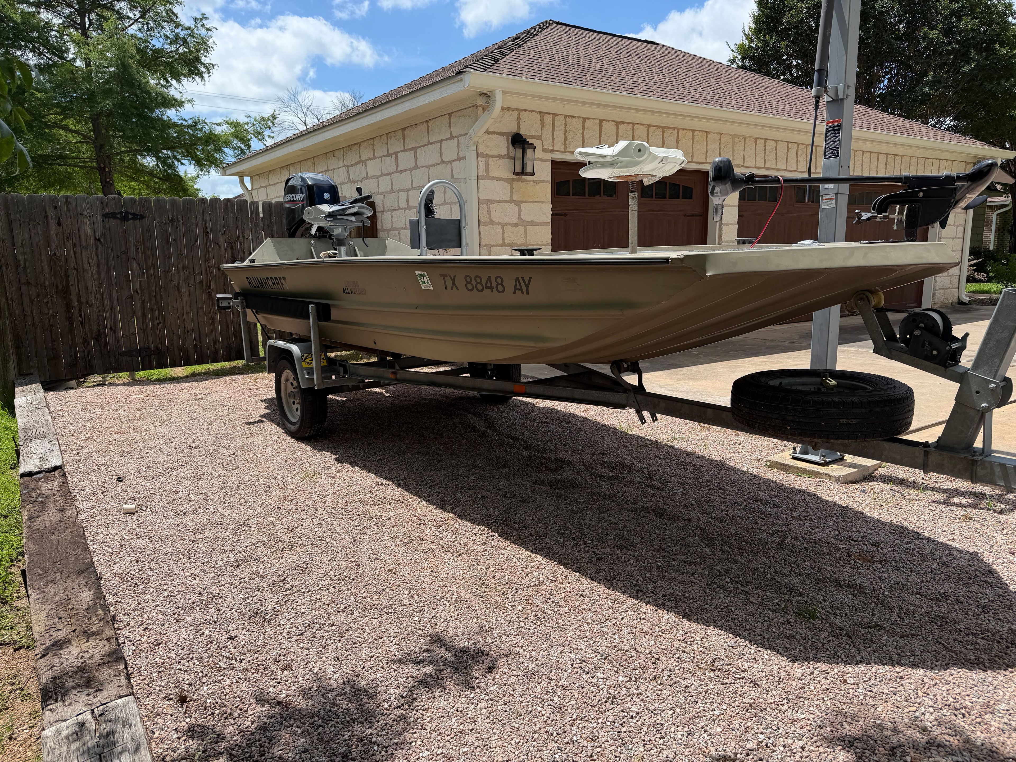 2008 Alumacraft Fisherman 160 Tiller on trailer in yard.