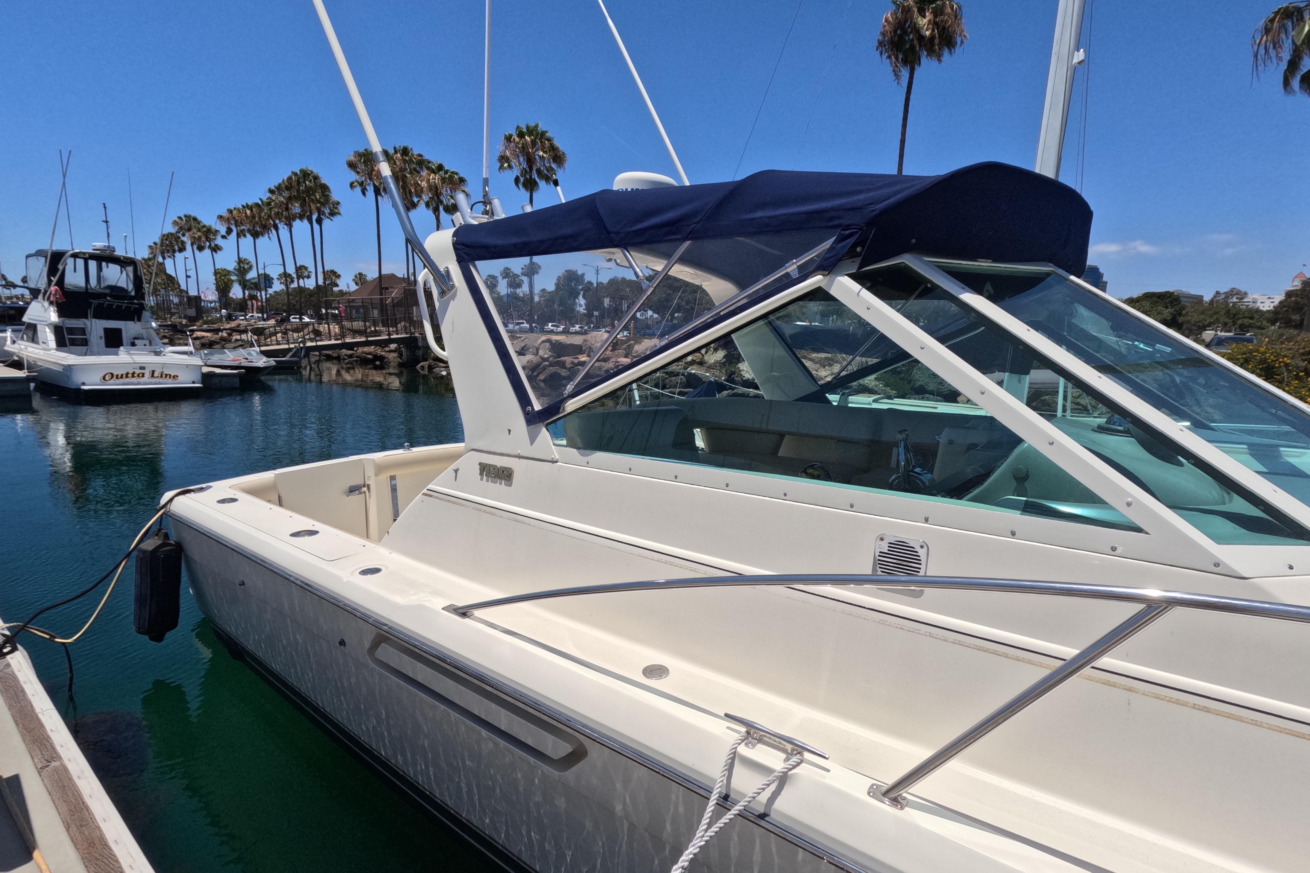 1995 Tiara Yachts 2900 Open docked, featuring sleek design and blue canopy.