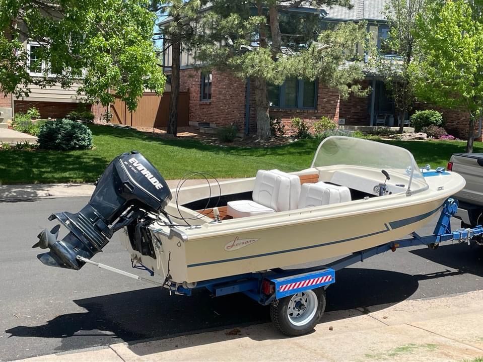 1962 Larsen 13 boat on trailer in residential area.