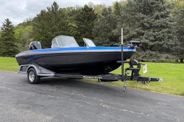 2025 Ranger 1850MS boat on trailer, parked on paved road with lush greenery.