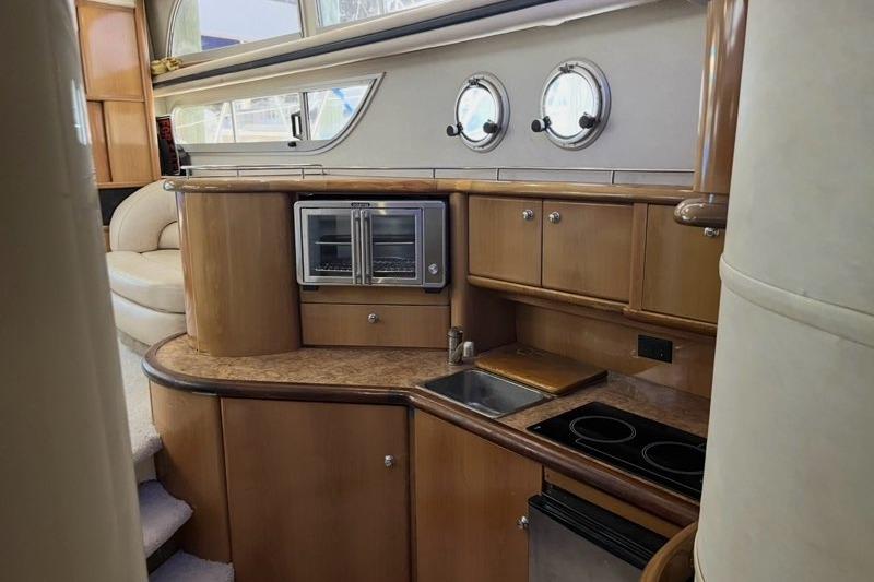 Interior of 1999 Sealine F44 yacht kitchen with wood cabinetry and modern appliances.