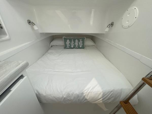 2025 Mag Bay 43 Center Console cabin with a cozy bed and modern lighting.