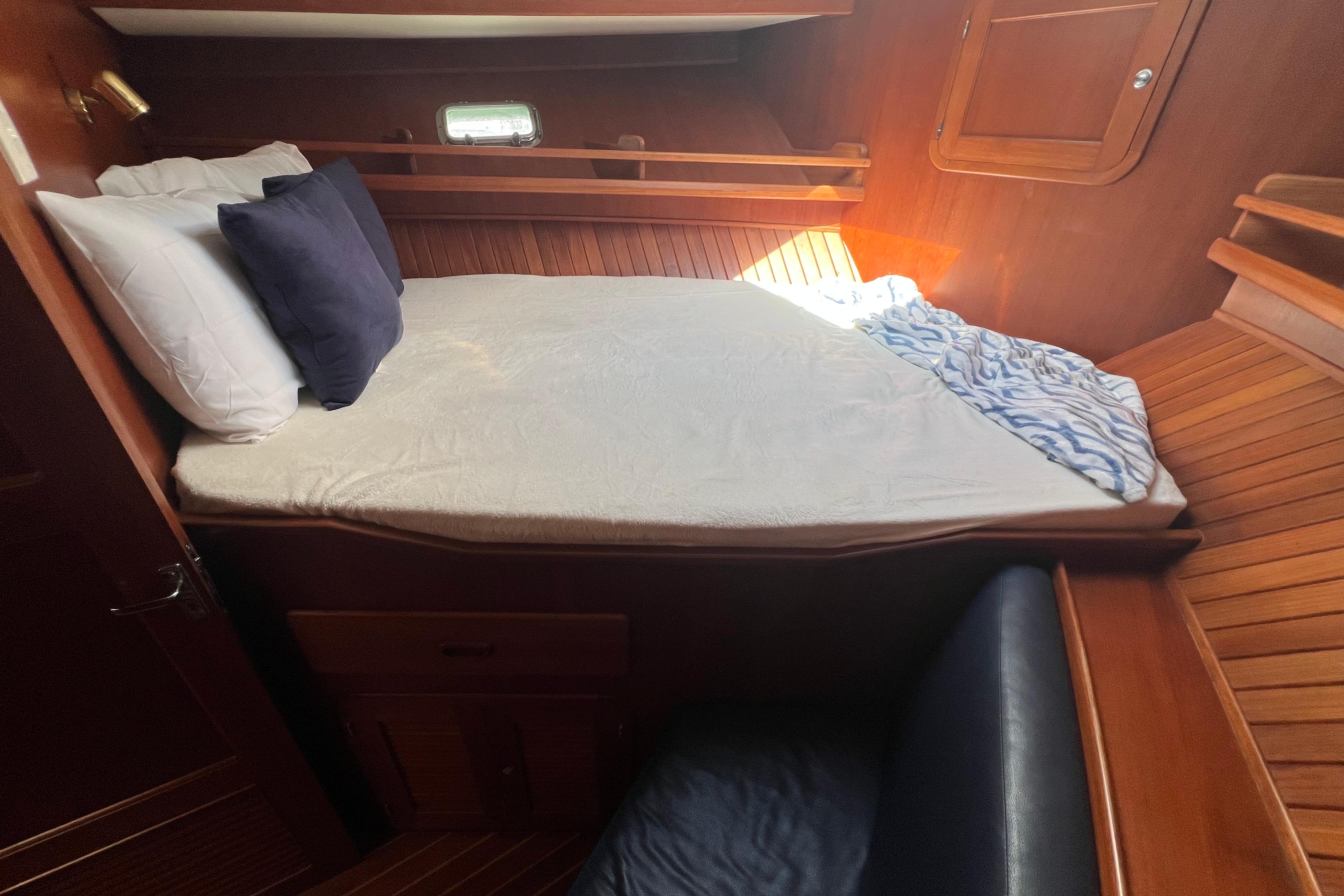 Cozy cabin interior of 2007 Heritage East 36 Sundeck Trawler with bed and wooden finish.