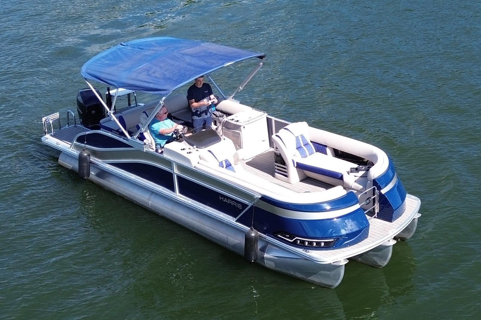 2022 Harris Grand Mariner 250 pontoon boat cruising on a lake with passengers.