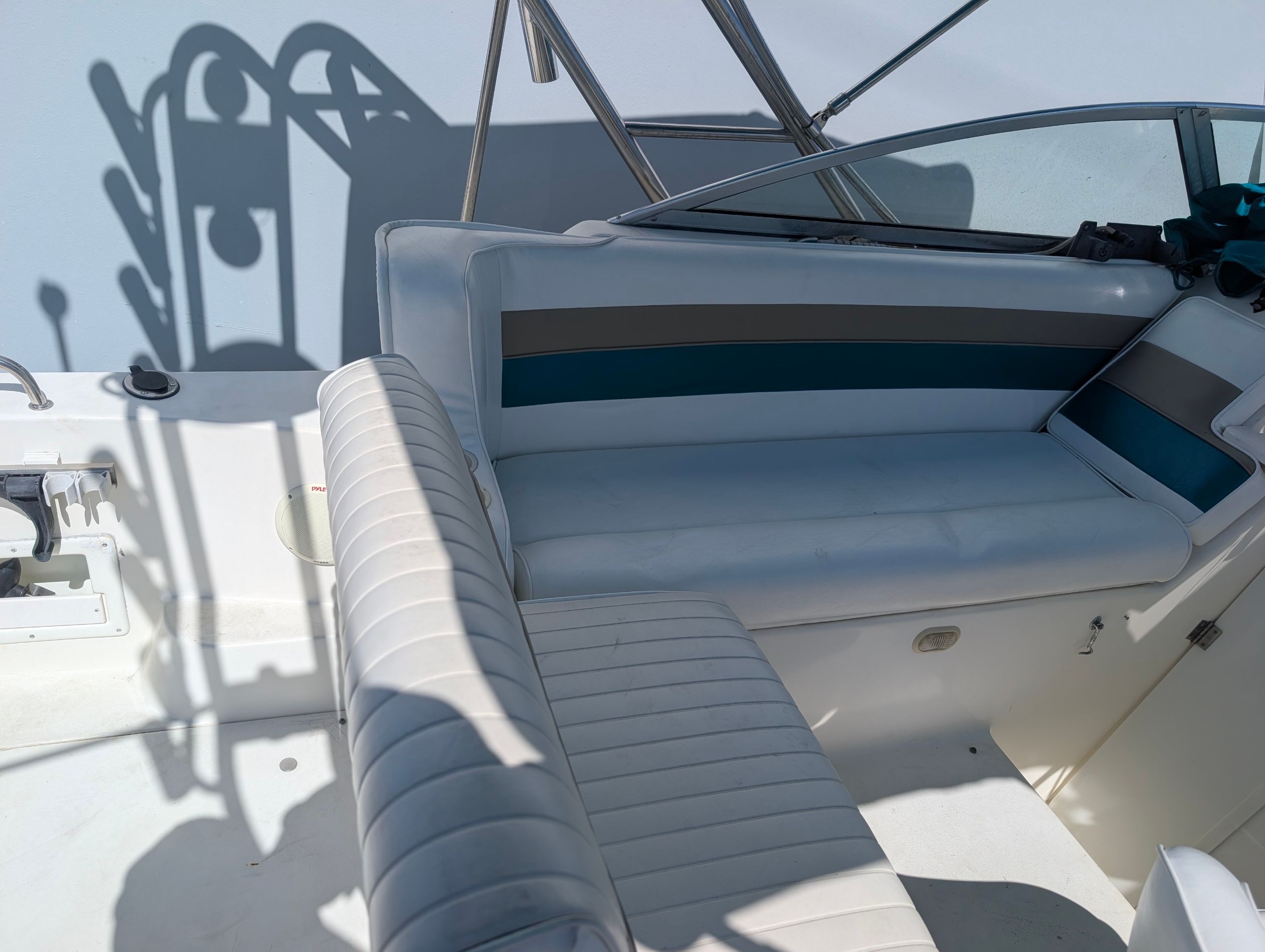 The image shows the cockpit of a 1995 Rinker Fiesta Vee 265 with white upholstered seats.