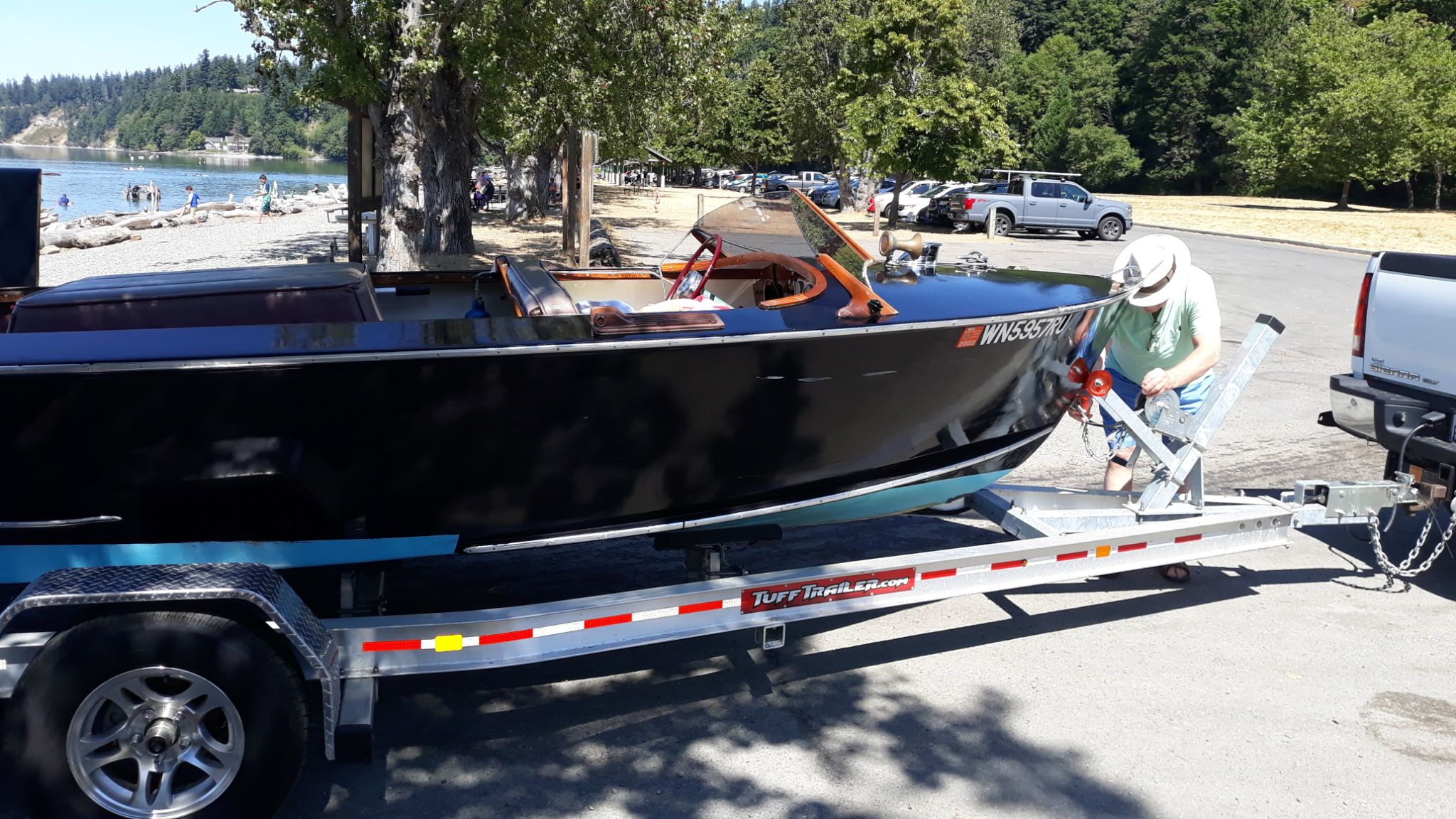 1948 Higgins 17.5 ft Runabout on trailer by lakeside.